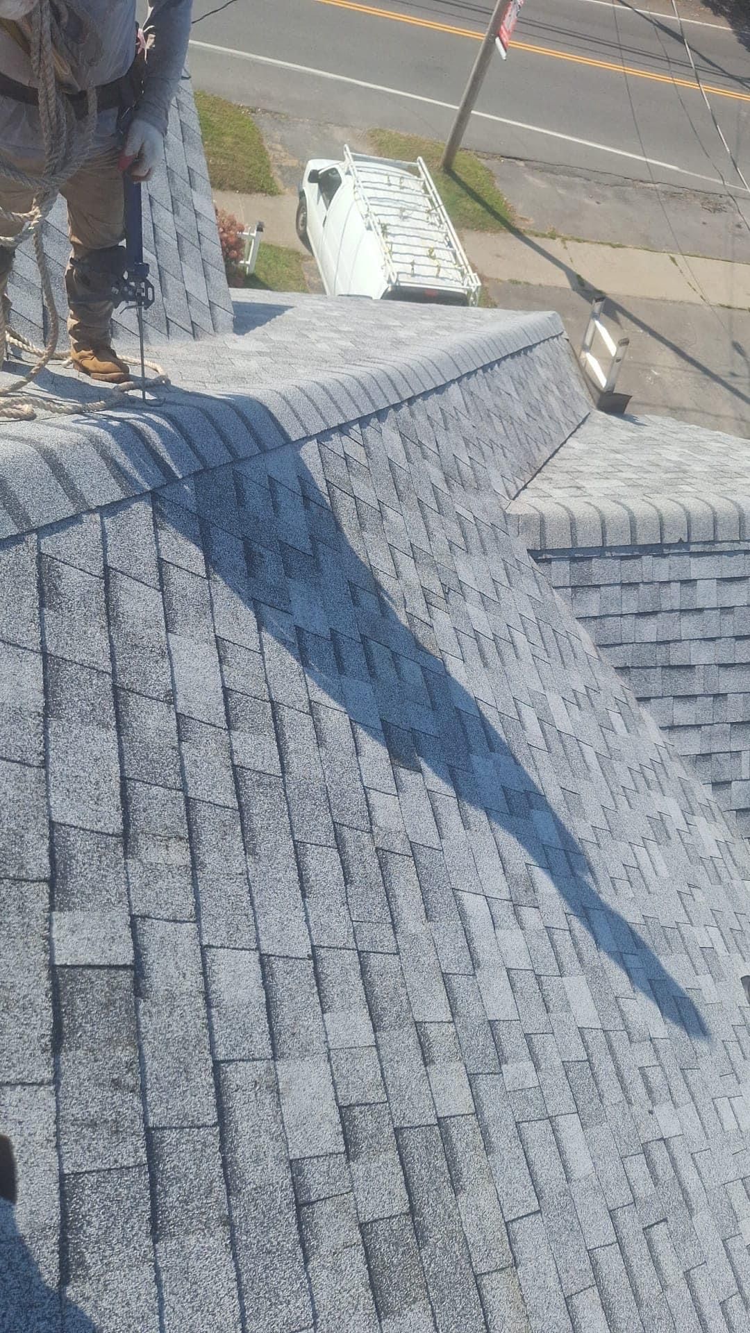 A man is standing on top of a roof.