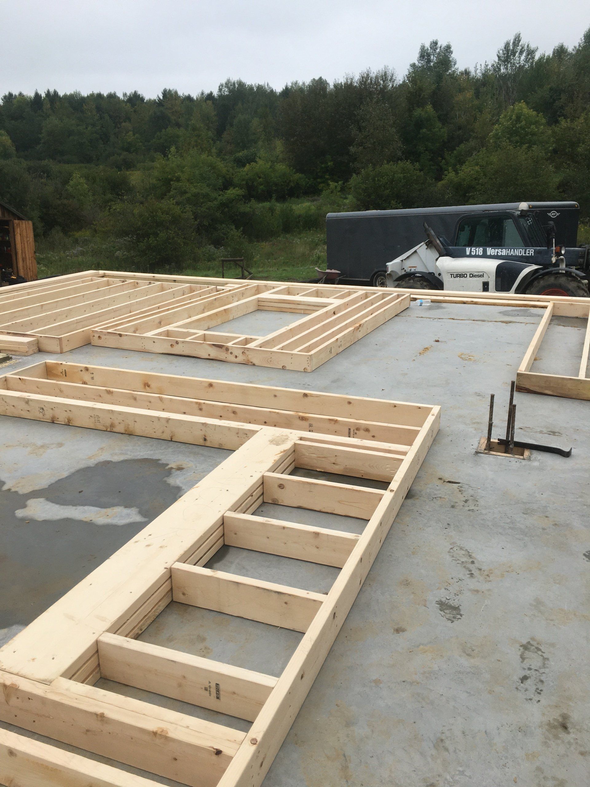 A large wooden structure is being built on a concrete floor.