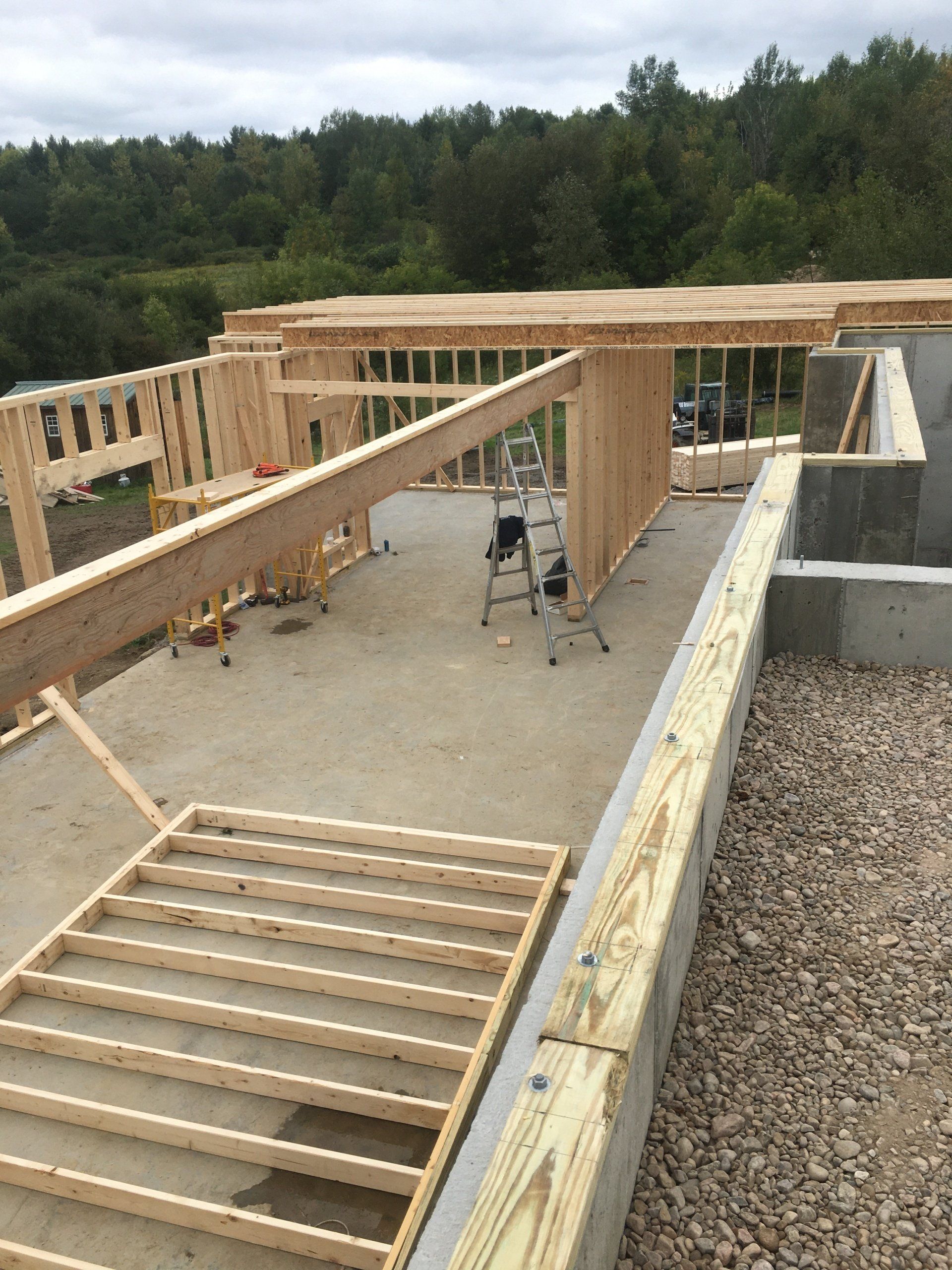 A wooden structure is being built on top of a gravel lot.