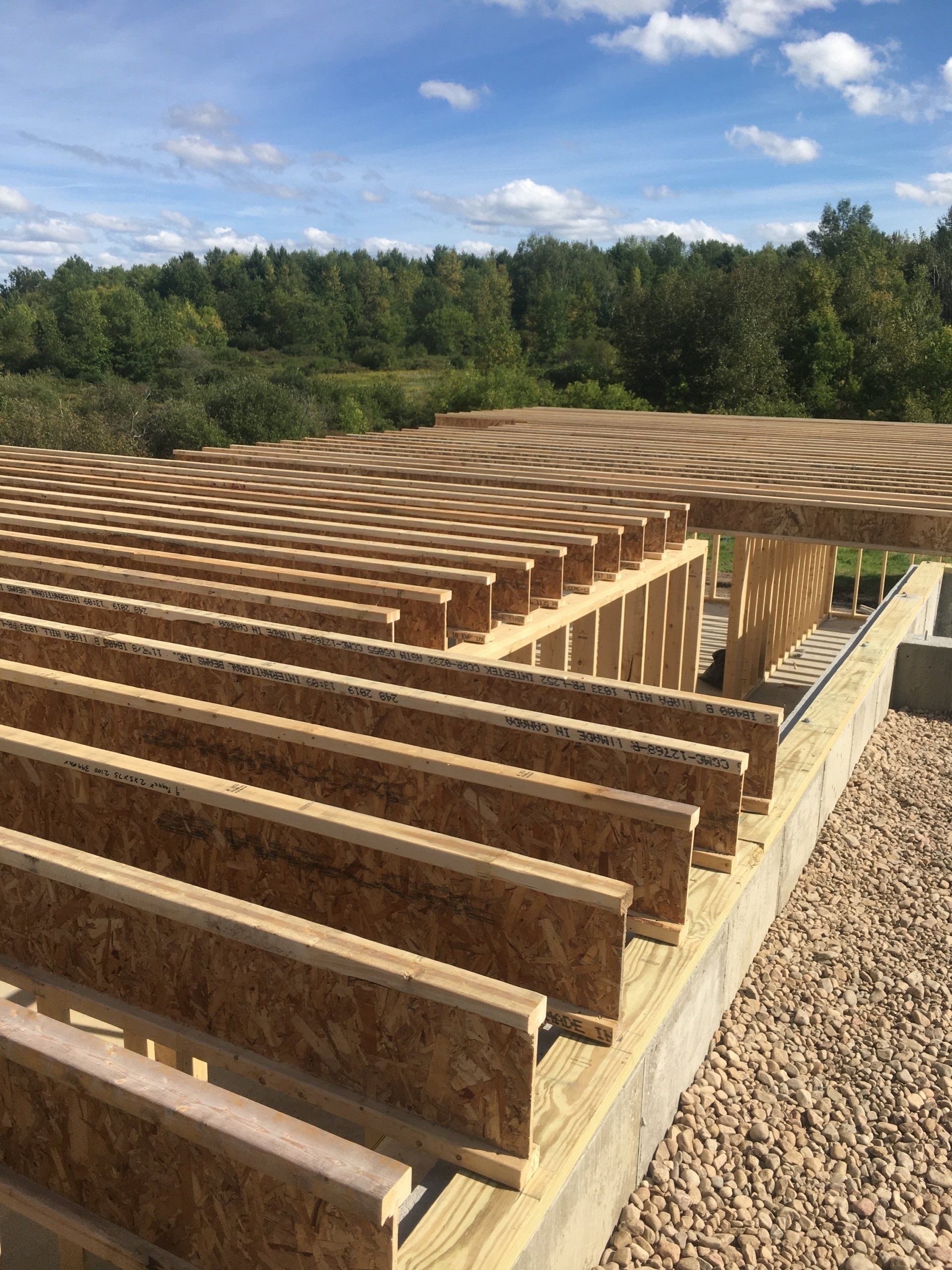 A row of wooden beams sitting on top of a gravel ground.