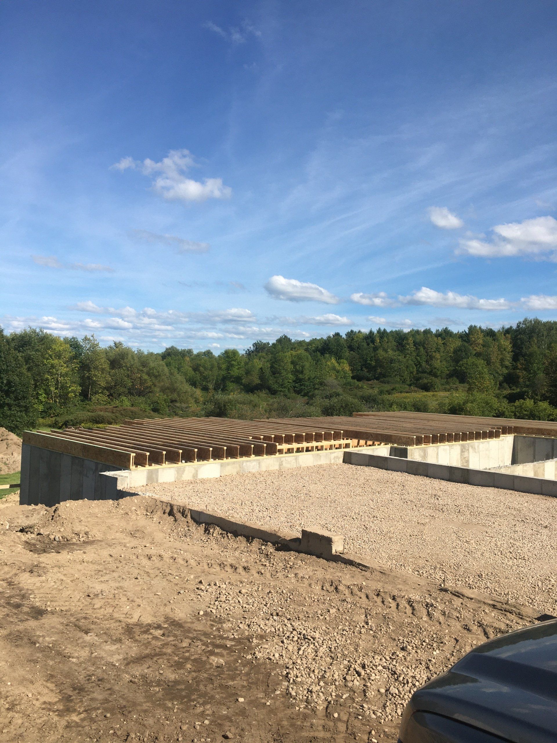 A concrete foundation is being built in a dirt field.
