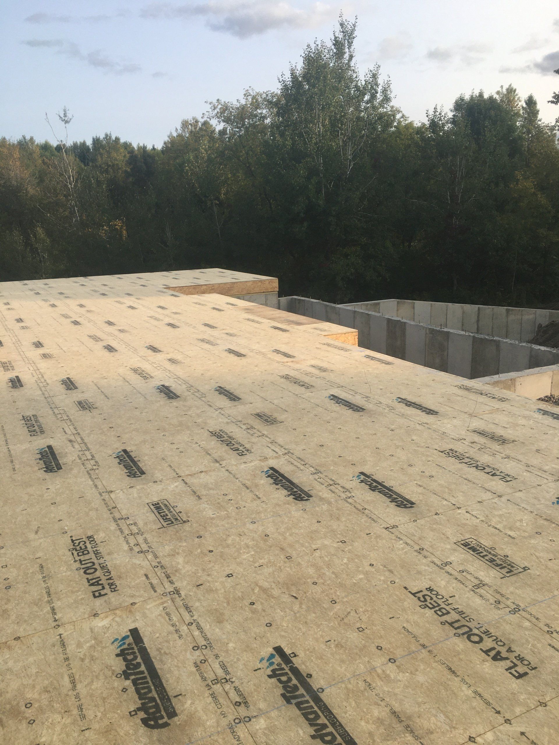A roof that is being built with a lot of trees in the background