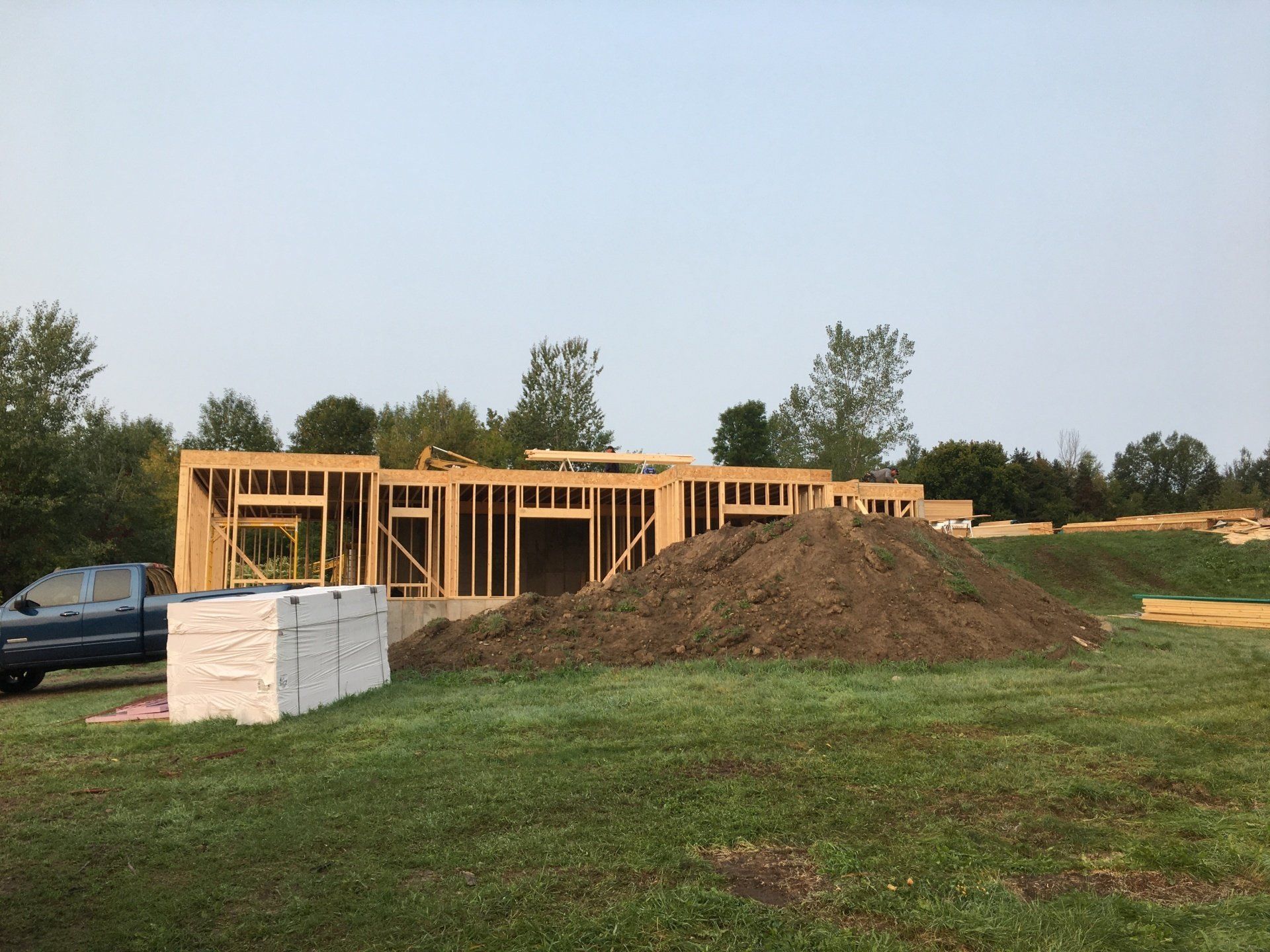 A truck is parked in front of a house under construction.