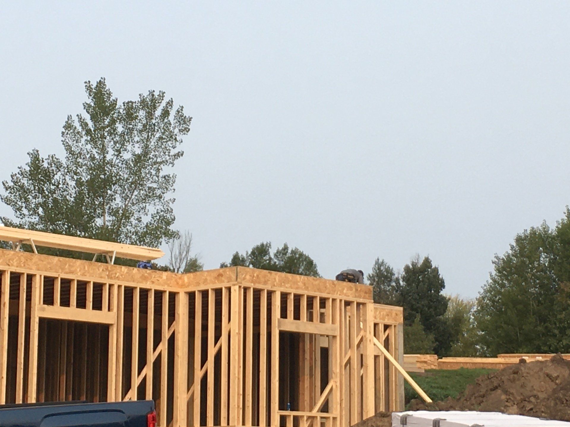 A truck is parked in front of a house under construction