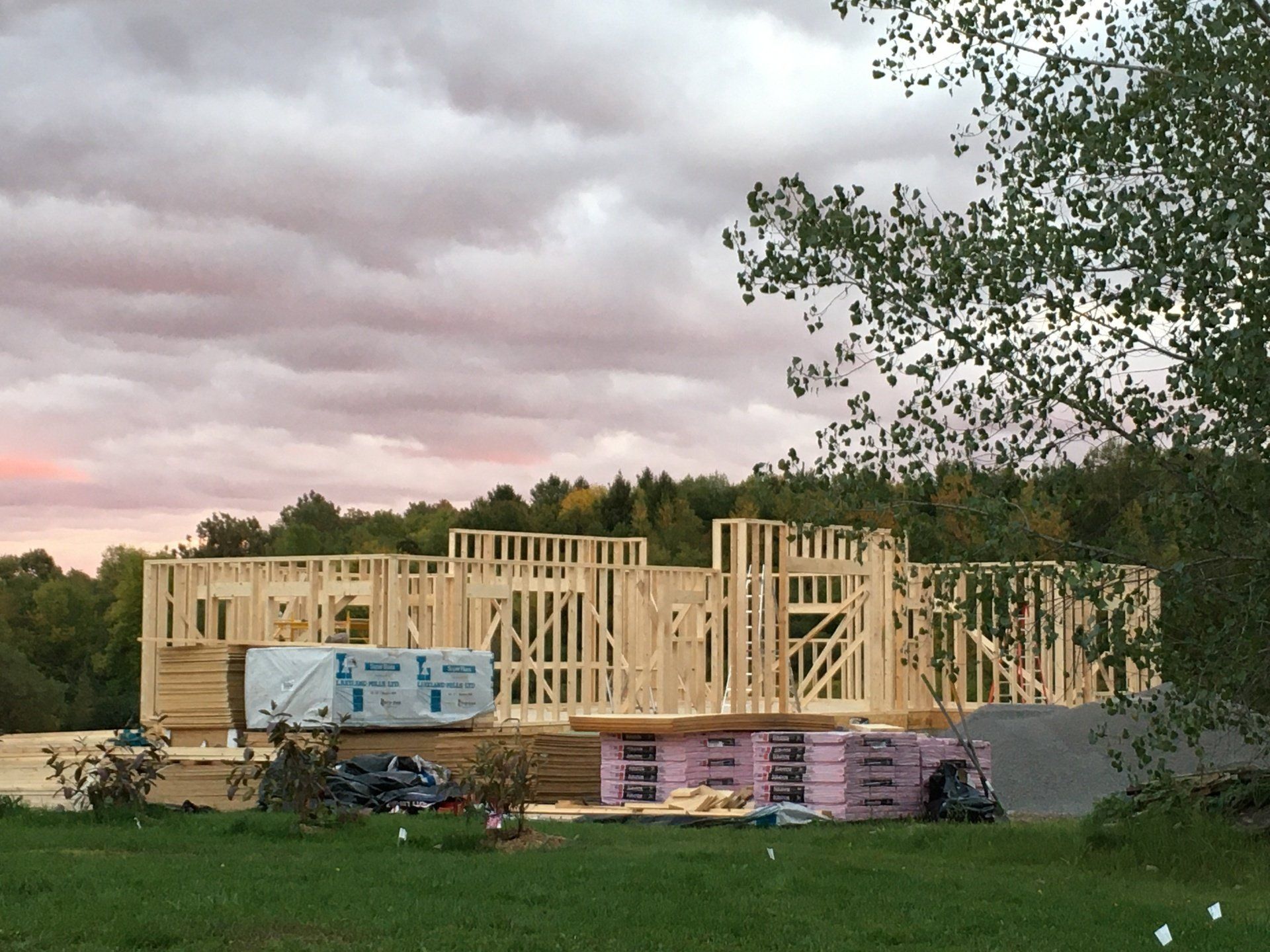 A house is being built in the middle of a grassy field