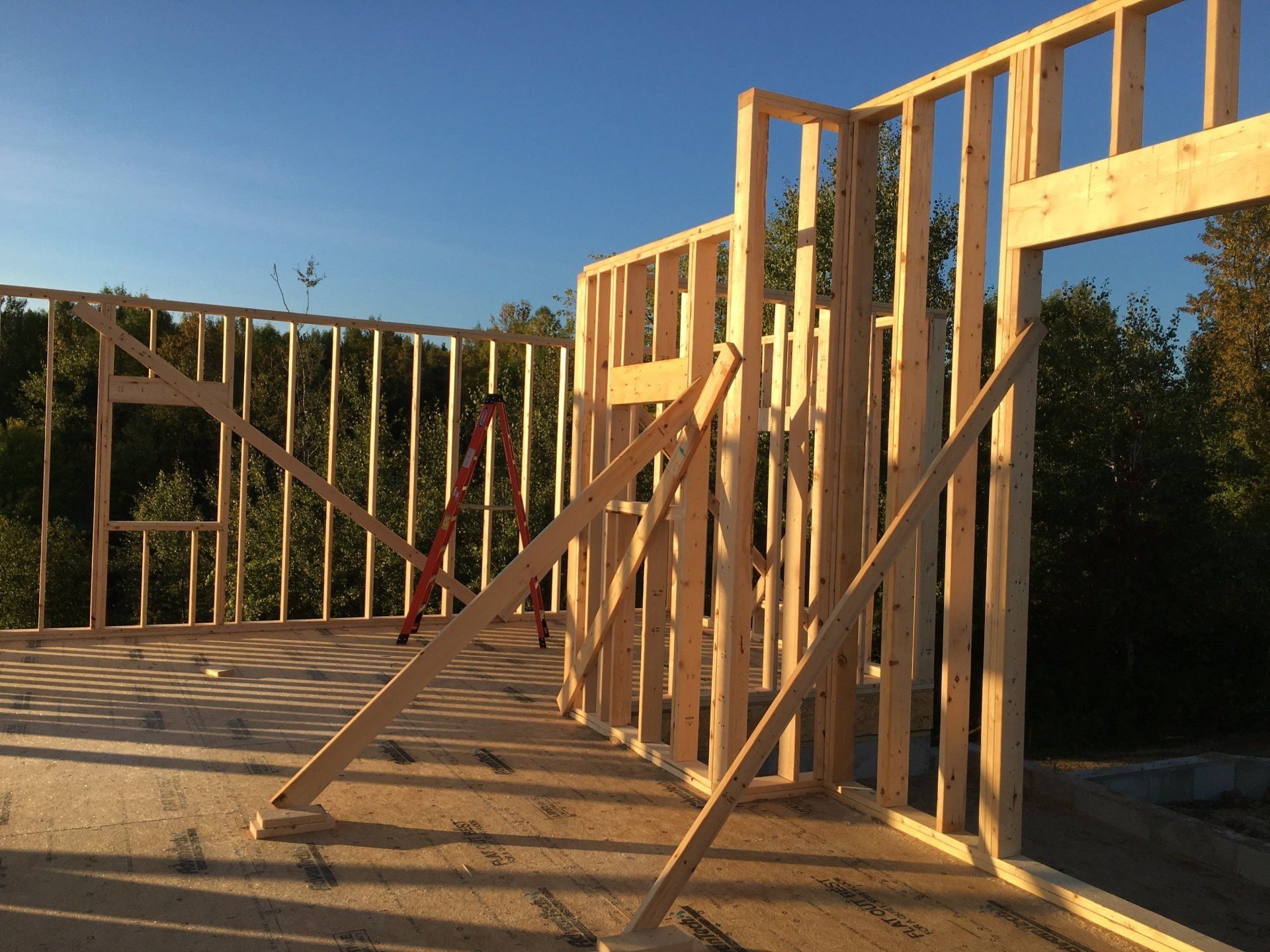 A wooden structure is being built with a blue sky in the background.
