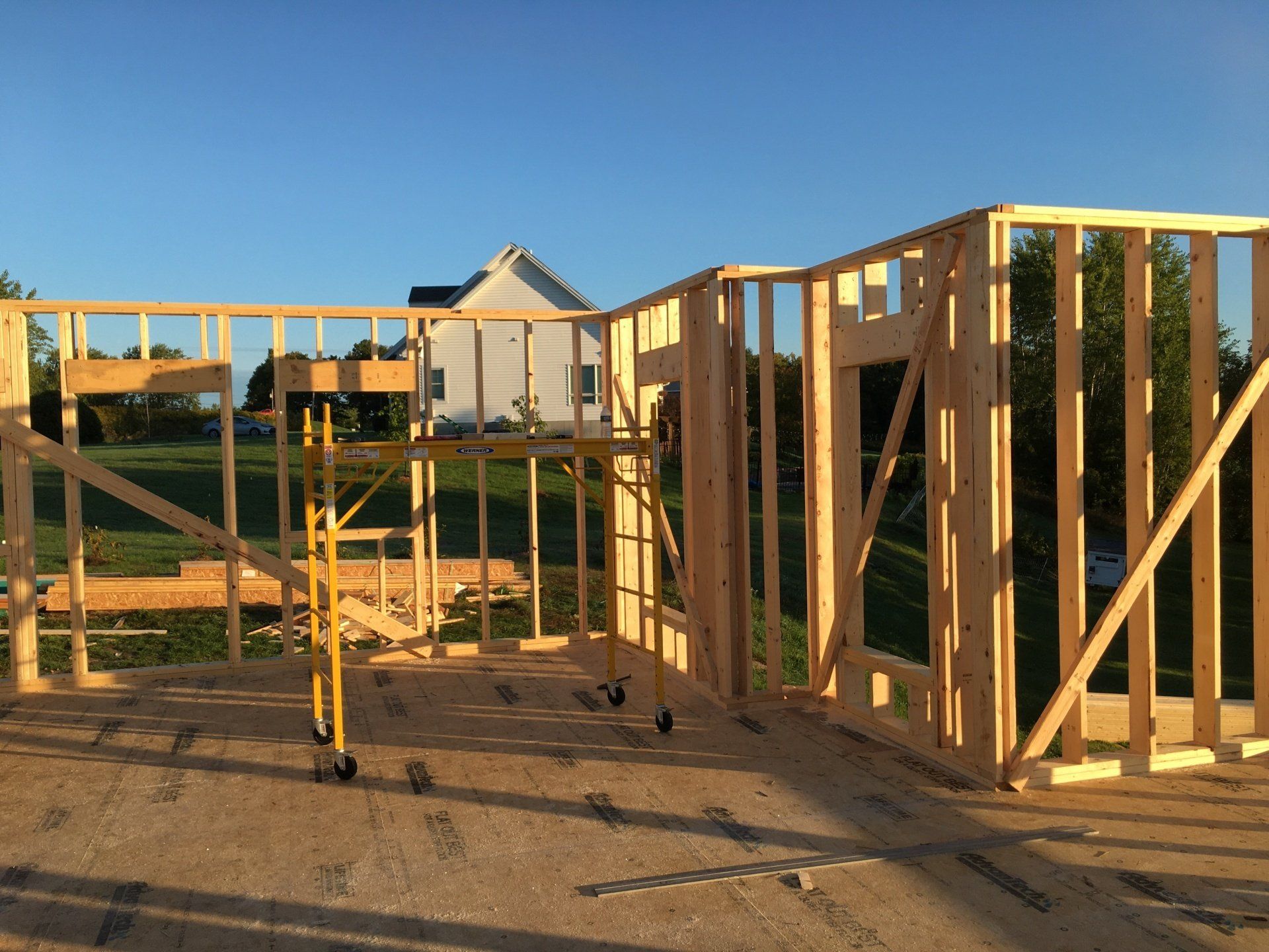 A house is being built with wooden frames and a scaffolding.