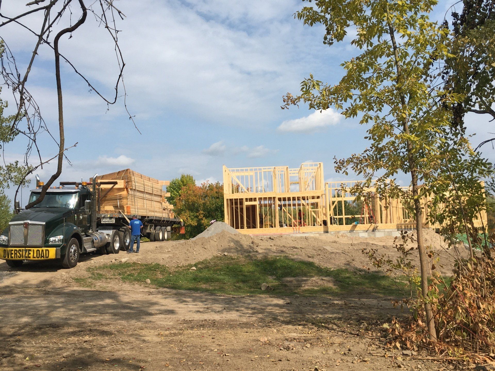 A truck is parked in front of a house under construction.
