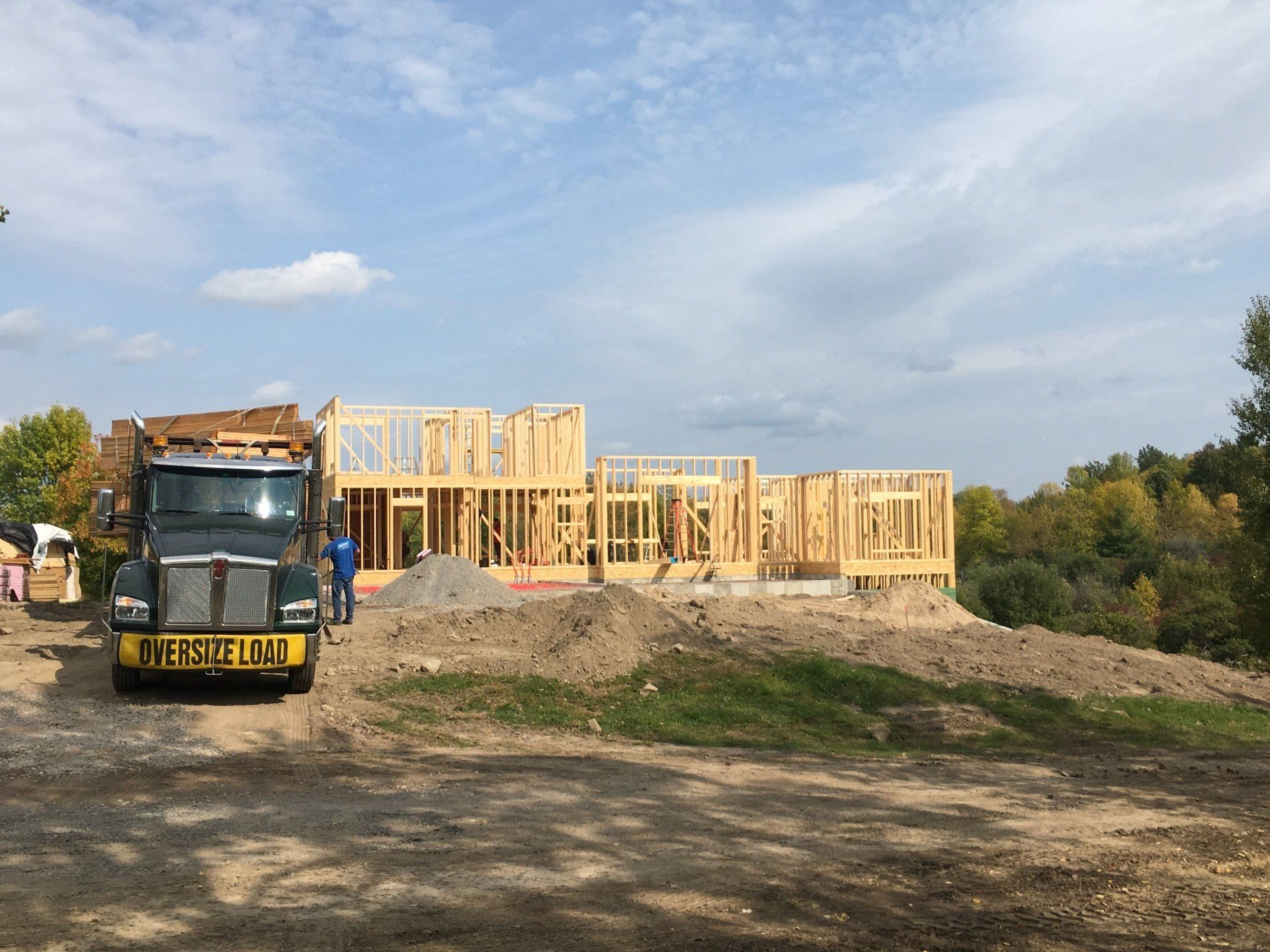 A truck is parked in front of a house under construction.
