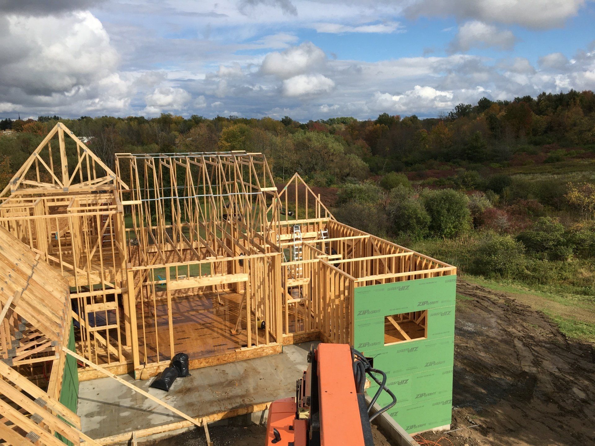A large wooden house is being built in the middle of a forest.