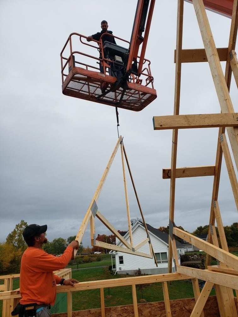 A man in an orange shirt is working on a wooden structure