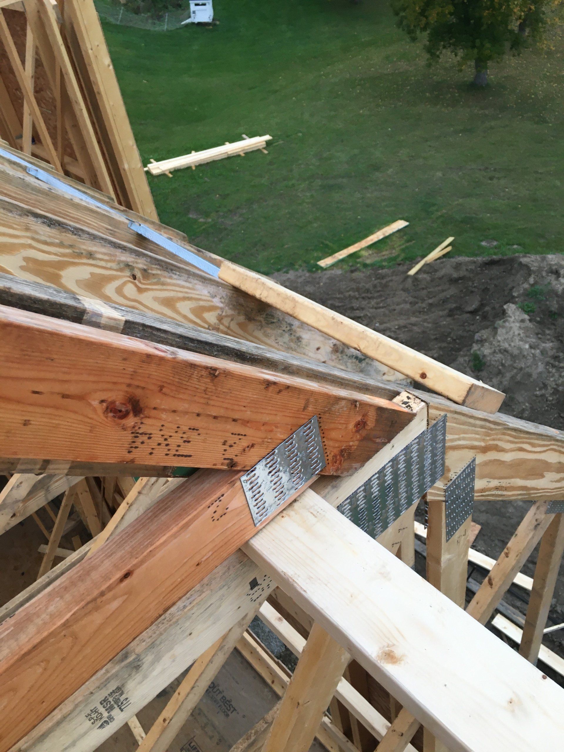 A wooden structure is being built on top of a lush green field.