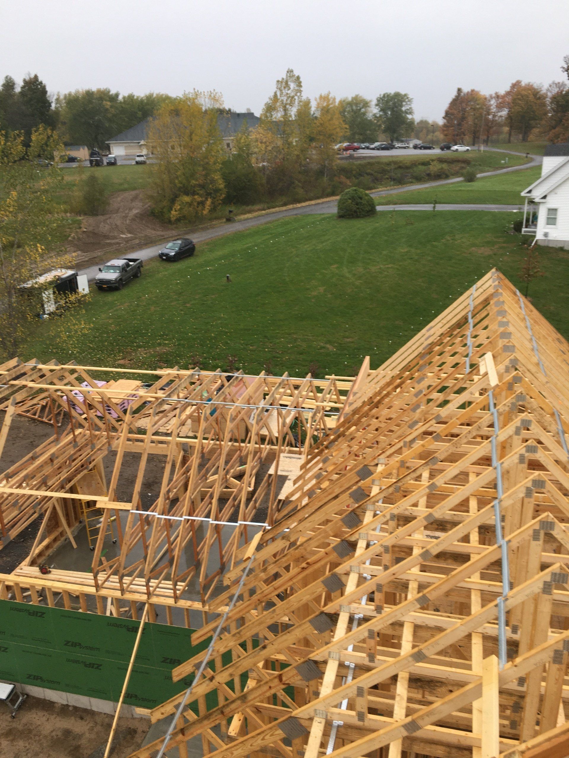 A large wooden structure is being built in a field.