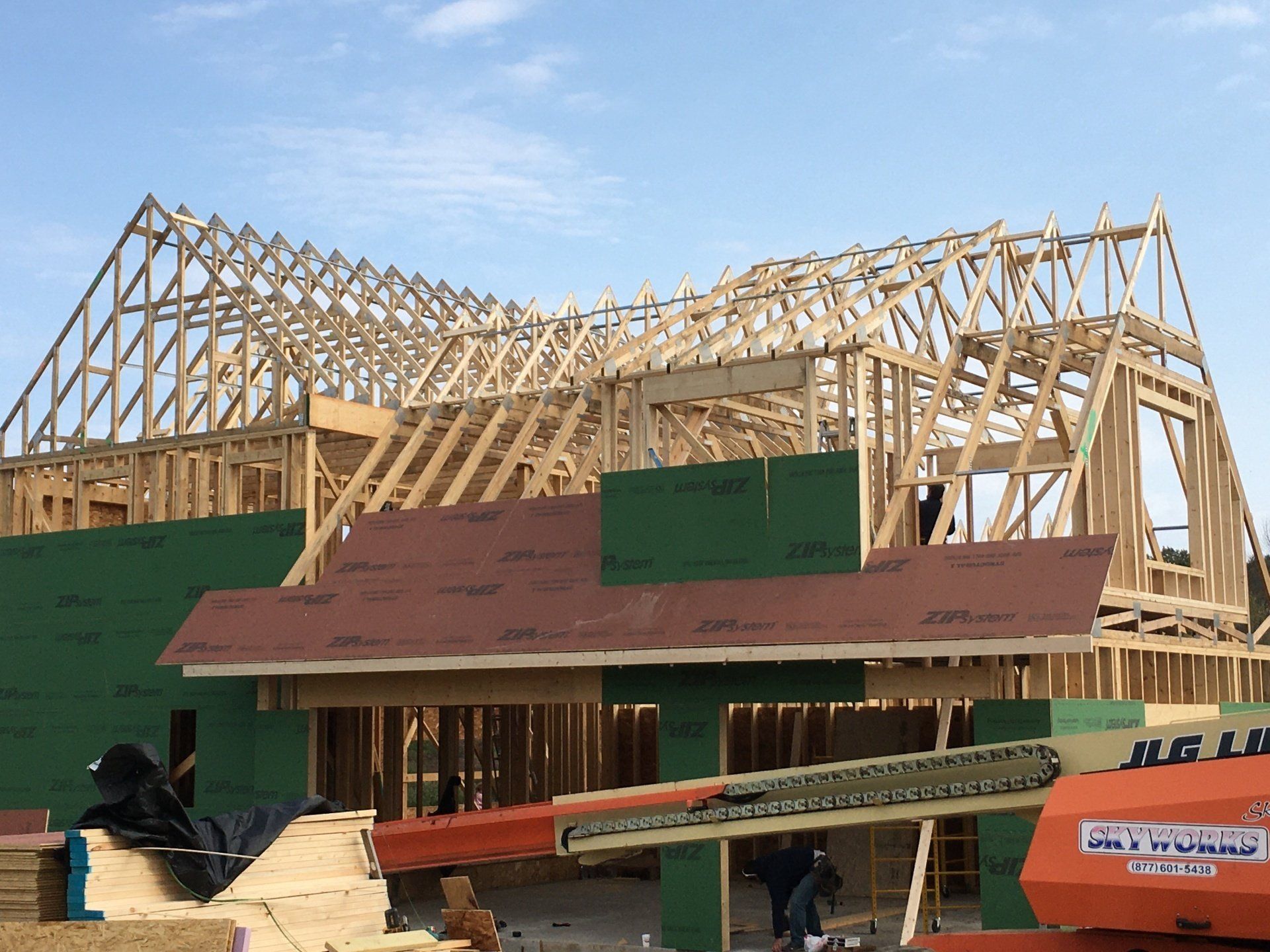 A house is being built with a jlg crane in the foreground