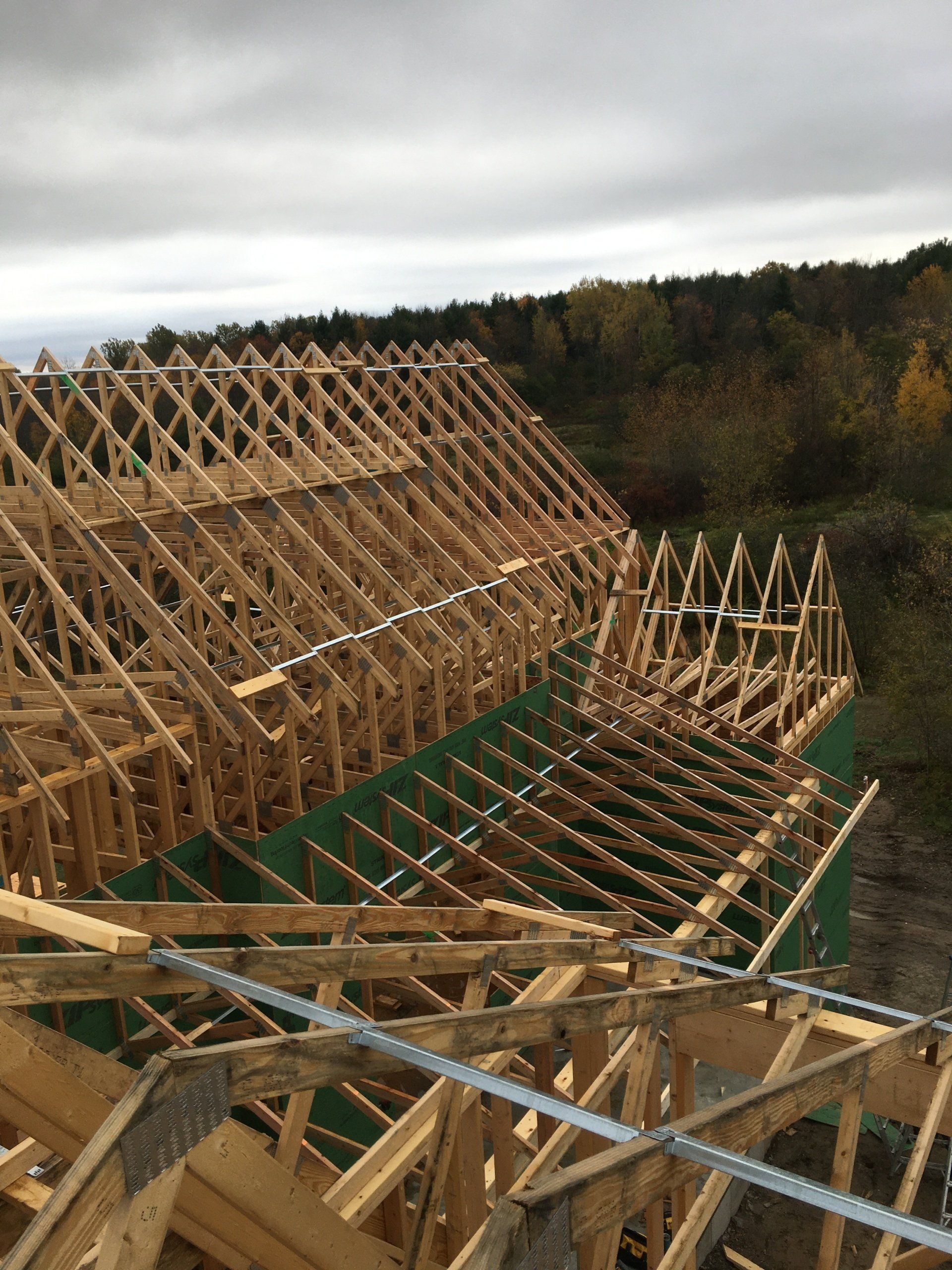 A large wooden structure is being built on top of a hill.