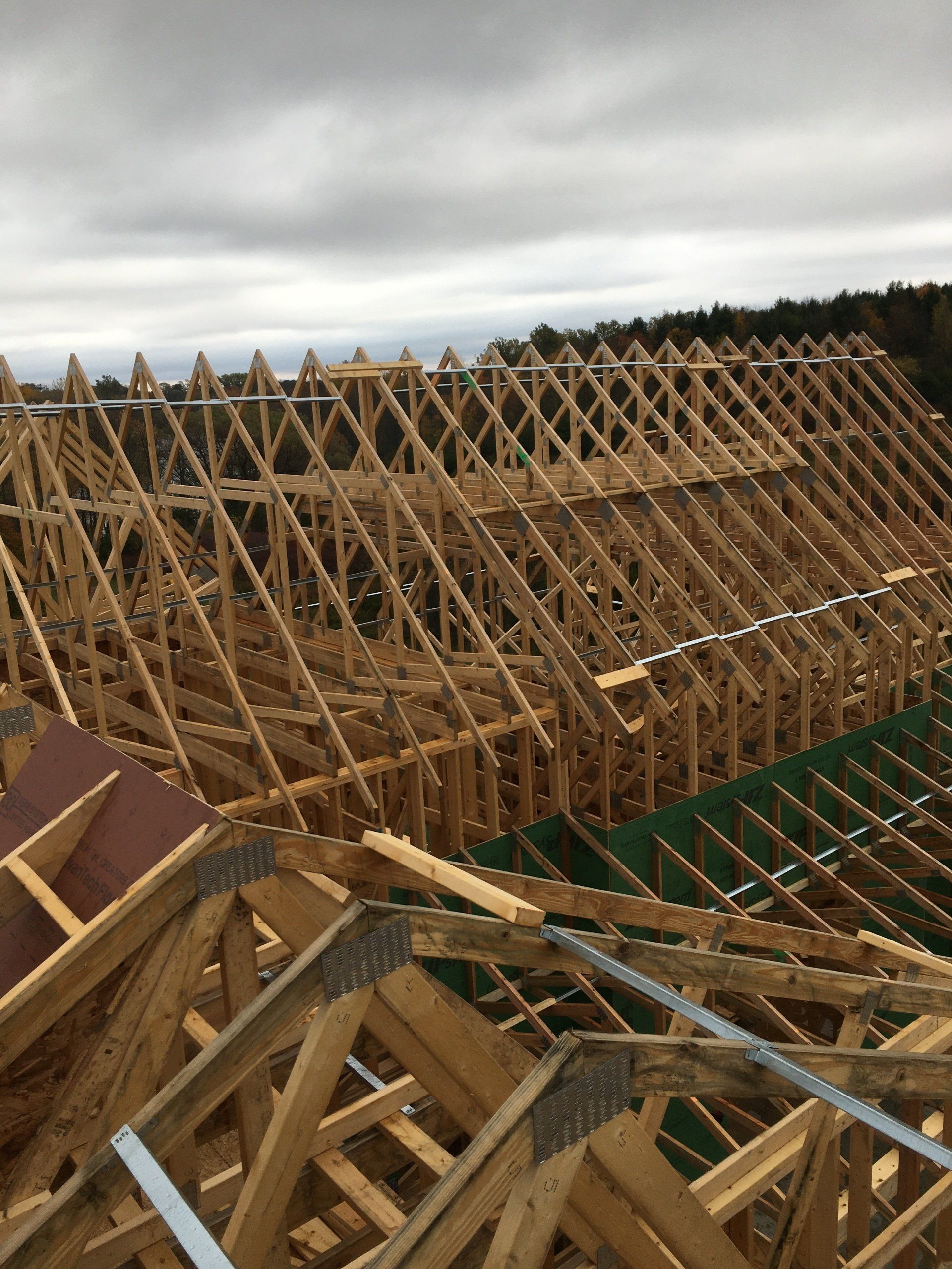 A large wooden structure is being built with a cloudy sky in the background.