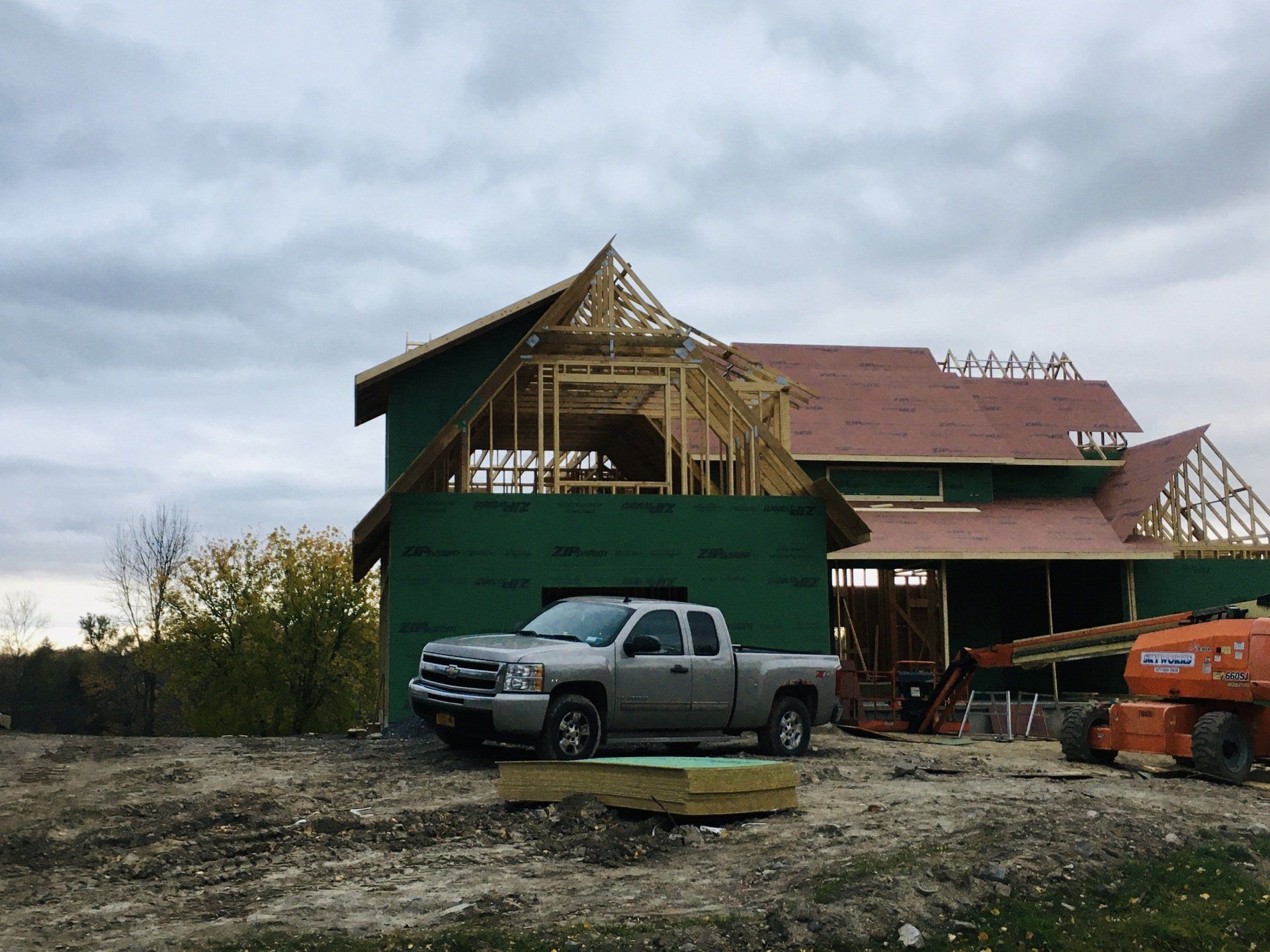 A truck is parked in front of a house under construction.