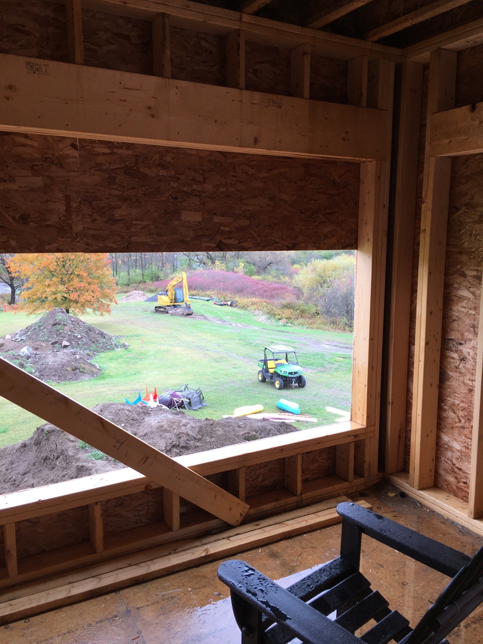 A chair is sitting in front of a window with a view of a field.