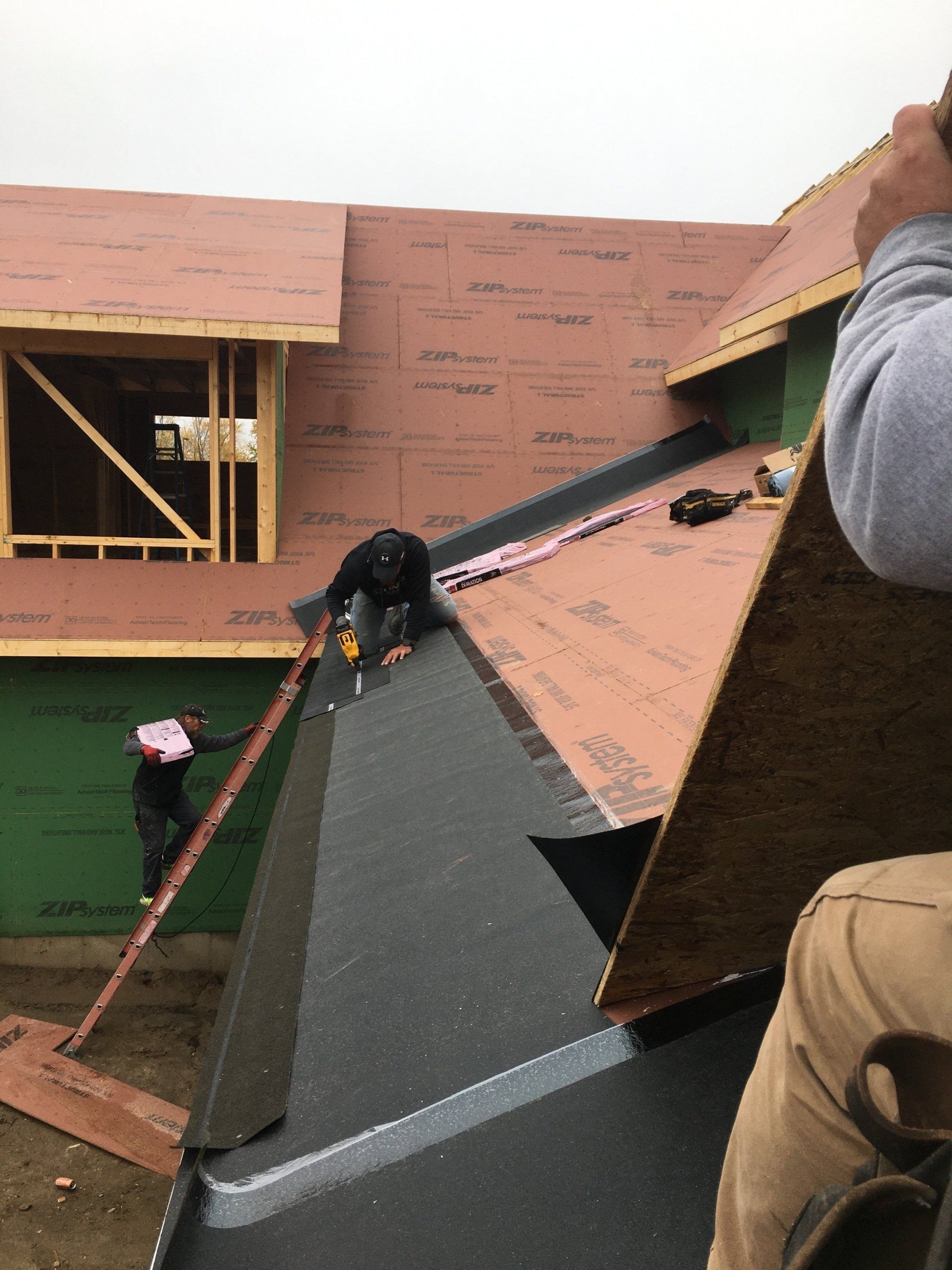 A man is working on the roof of a house under construction.