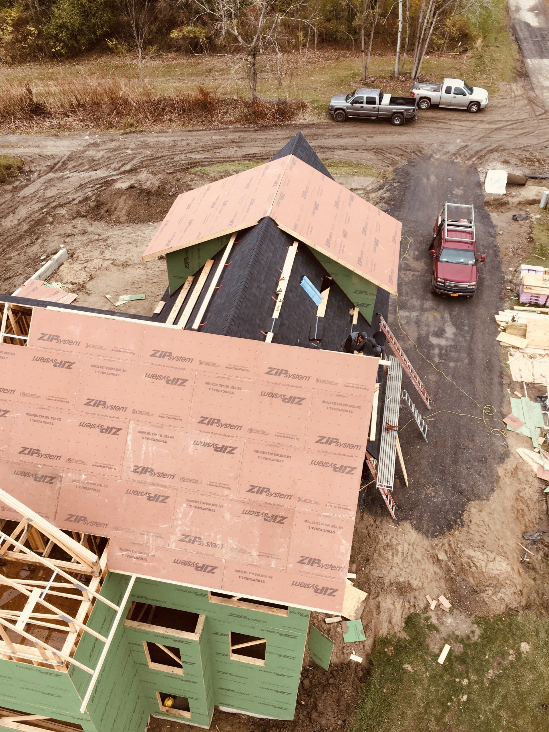 An aerial view of a house under construction with a red truck parked in front of it.