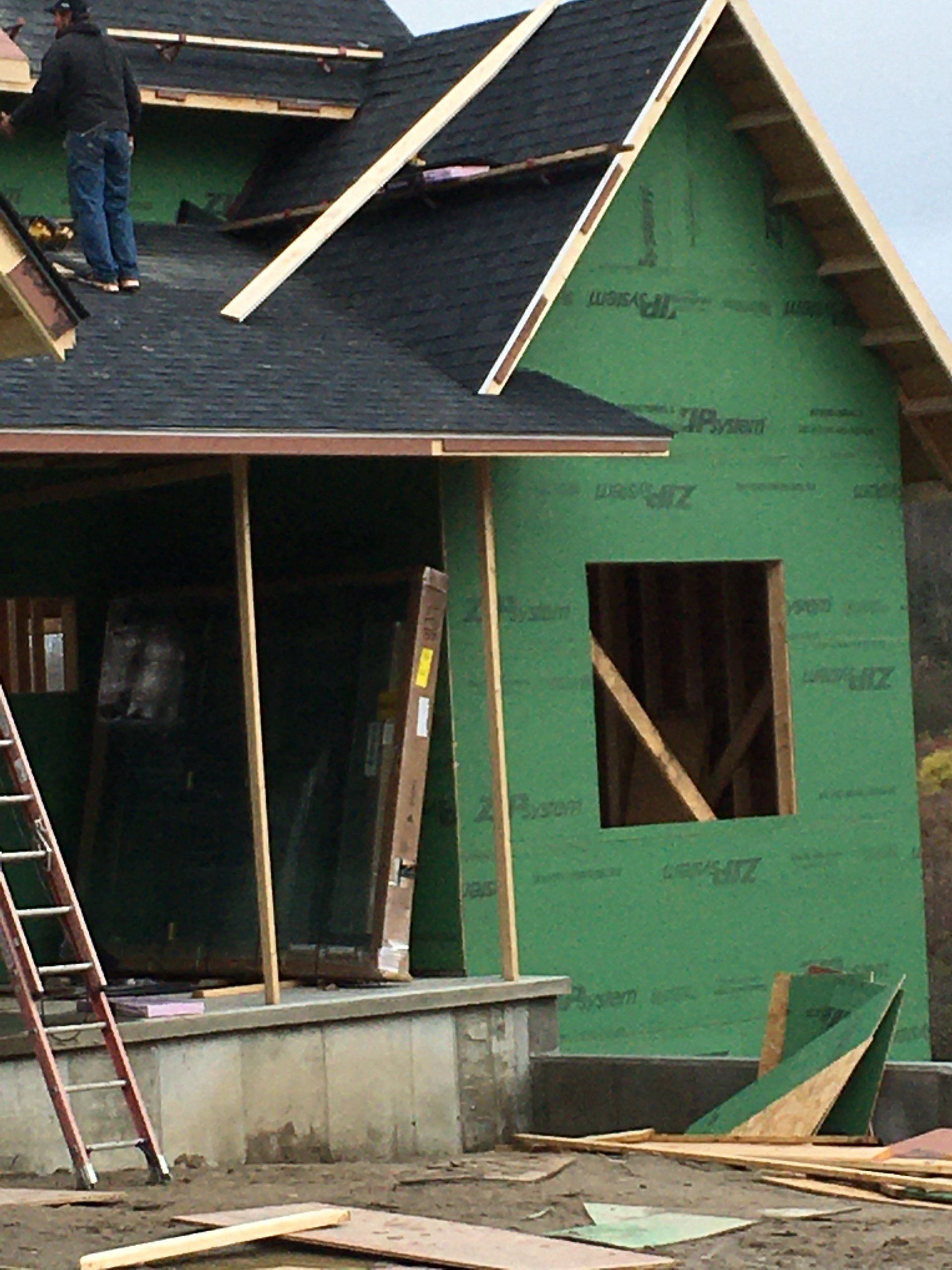 A man is working on the roof of a house