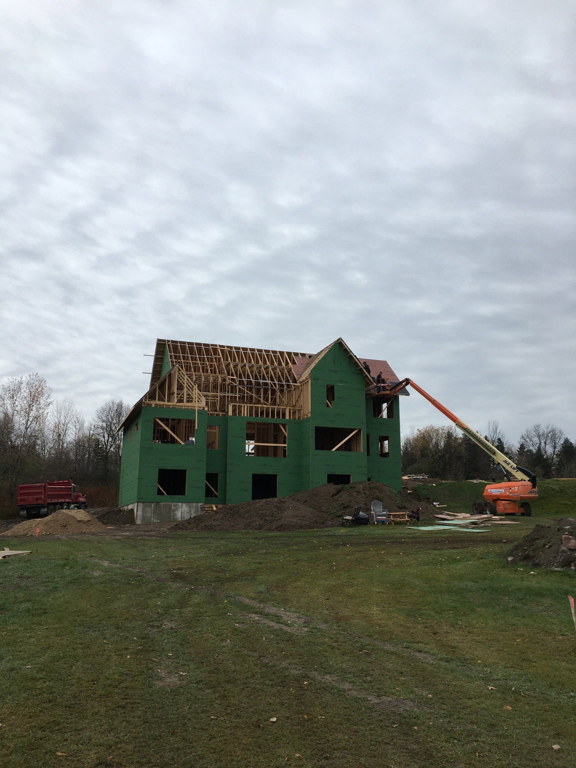 A green house is being built in a grassy field.