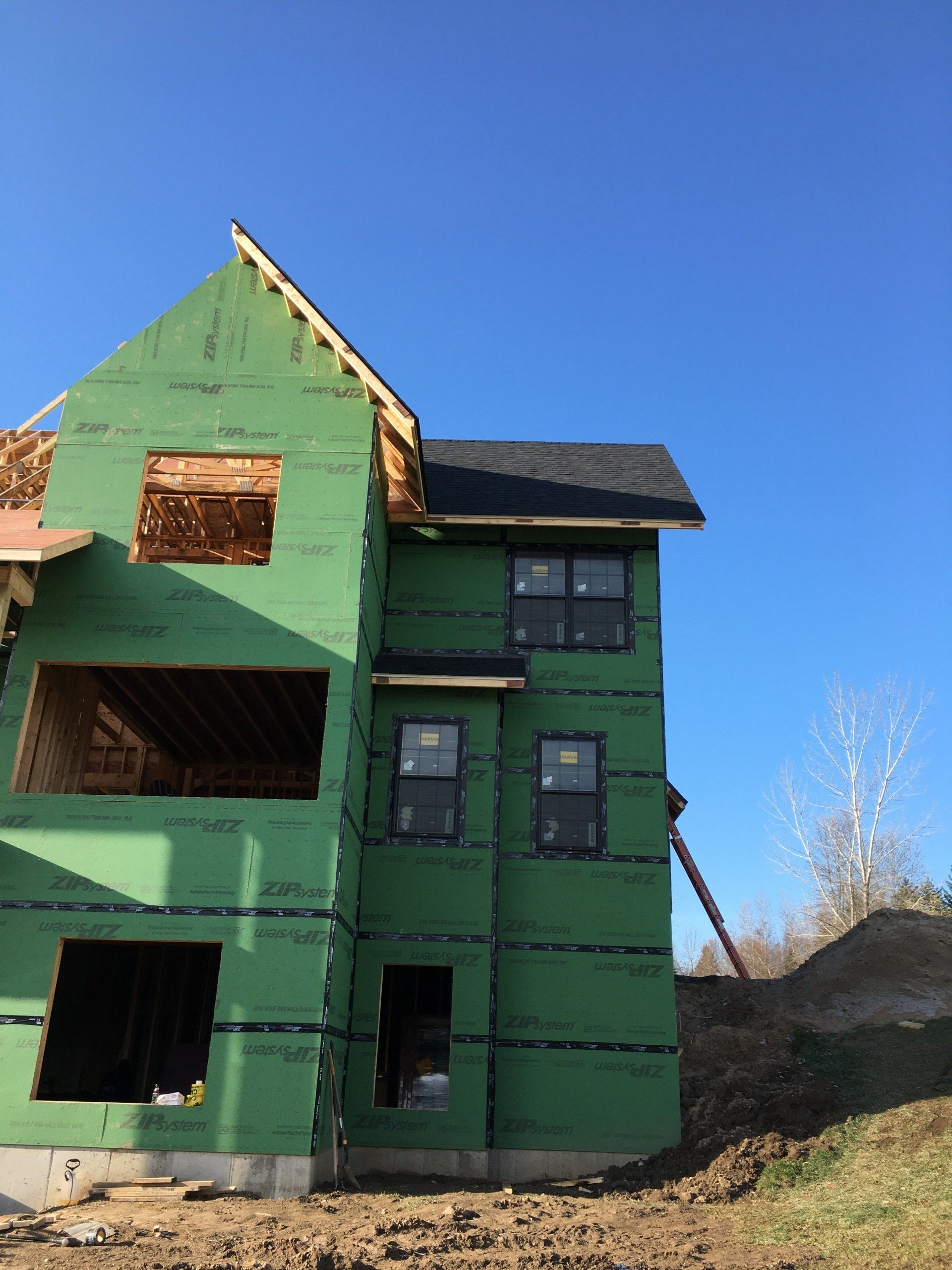 A green house is being built with a blue sky in the background.