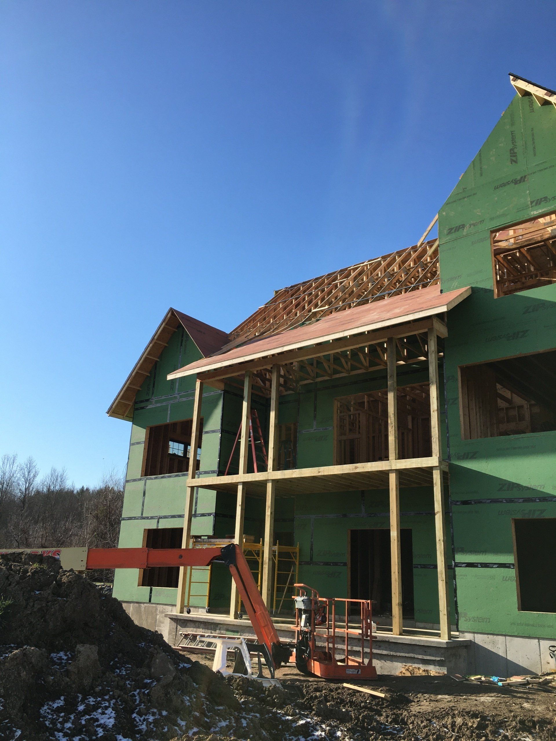 A house is being built with green walls and a red roof