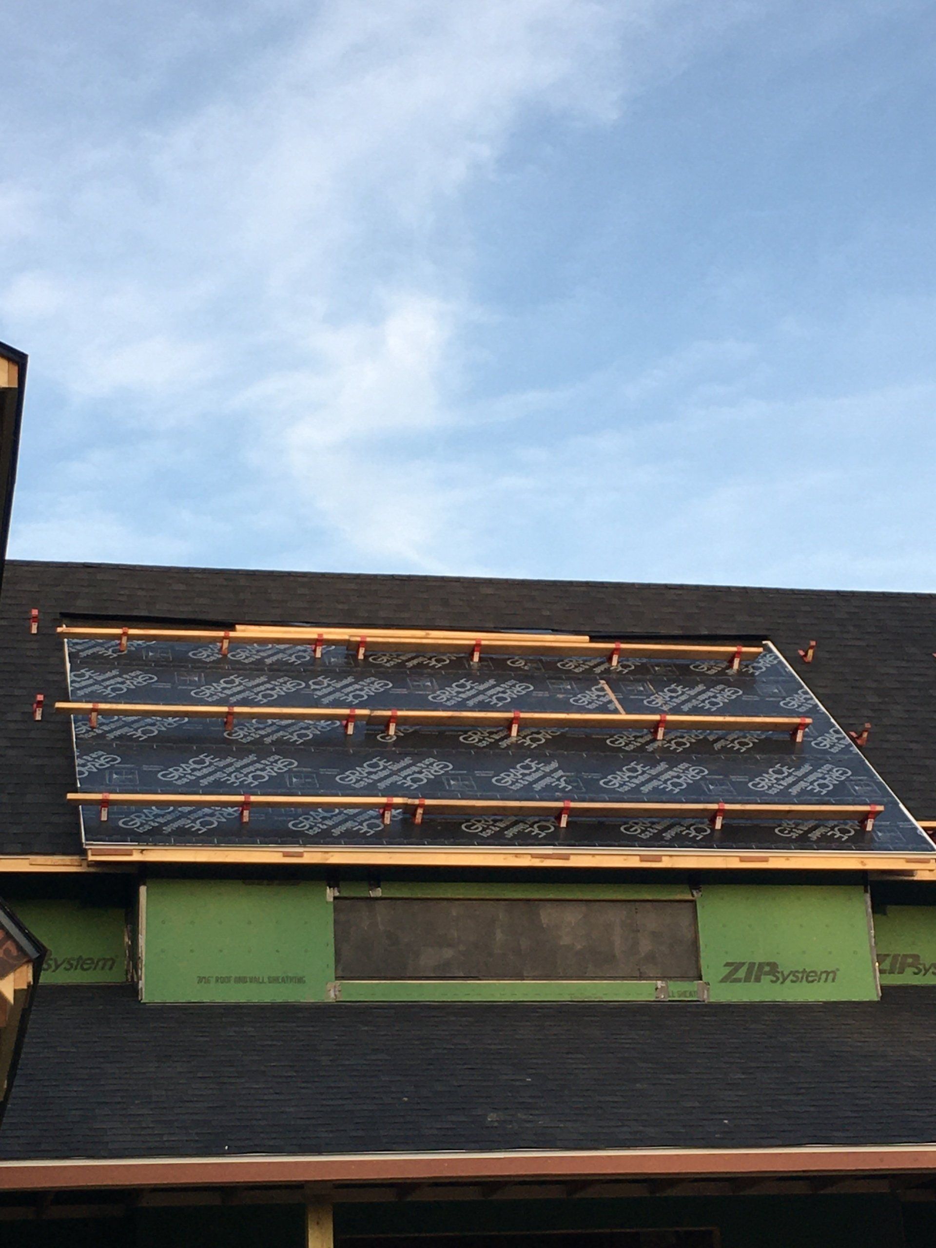 A roof that is being built with a blue sky in the background
