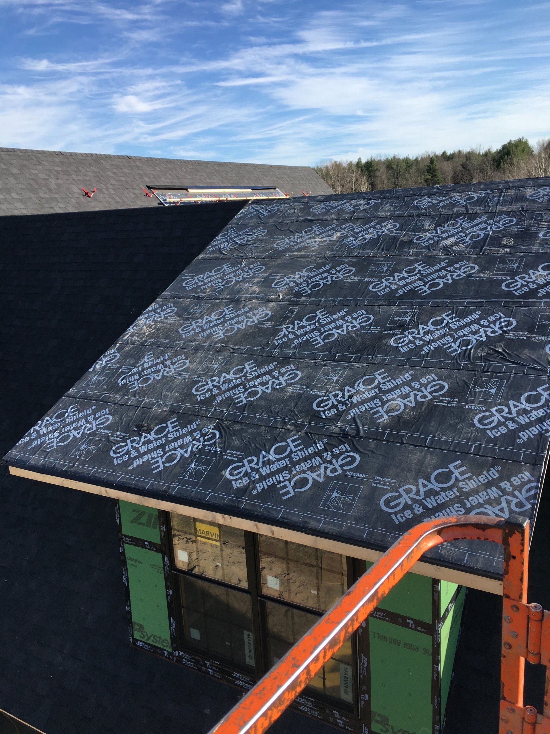A black roof is being installed on a house.