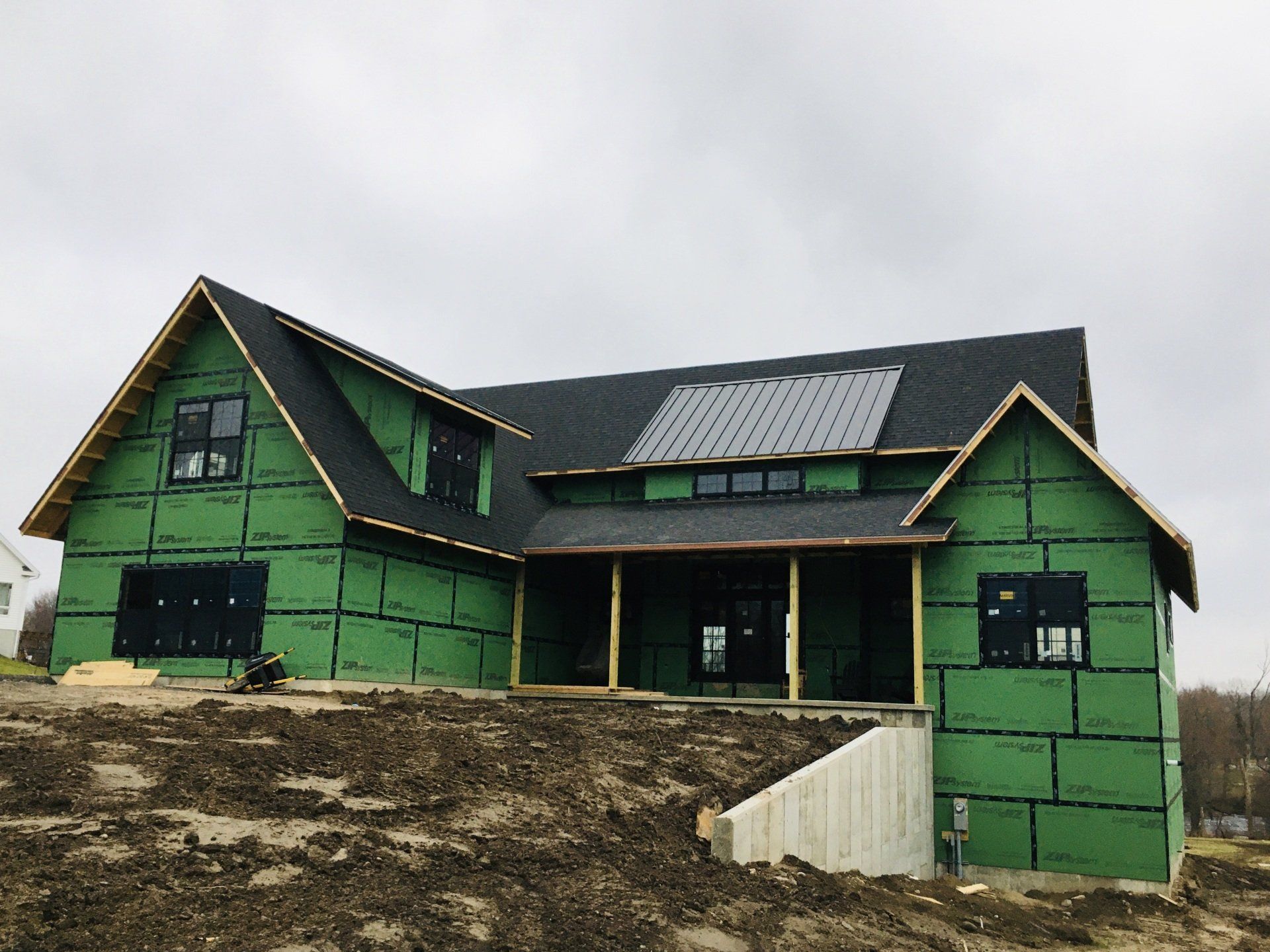 A house is being built with green insulation and solar panels on the roof