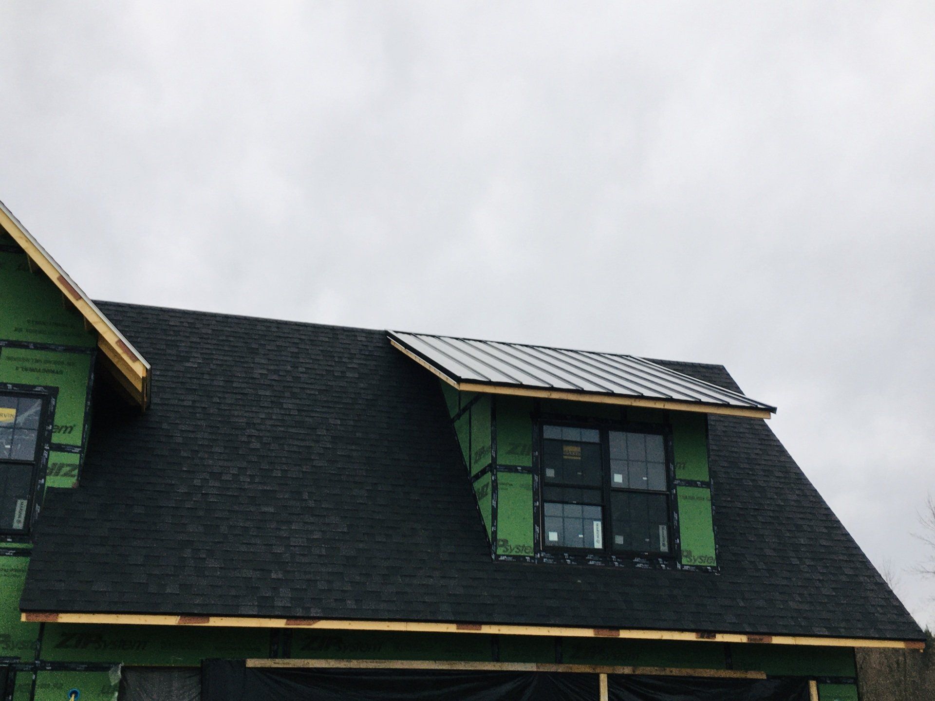 A house under construction with a black roof