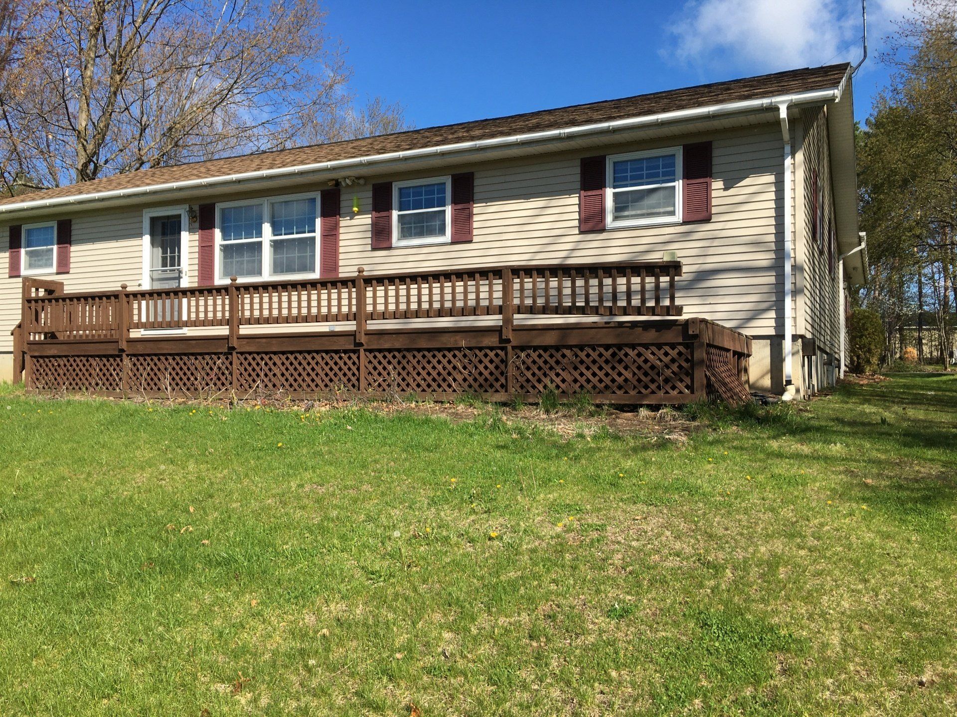 A house with a large deck and a fence in front of it.