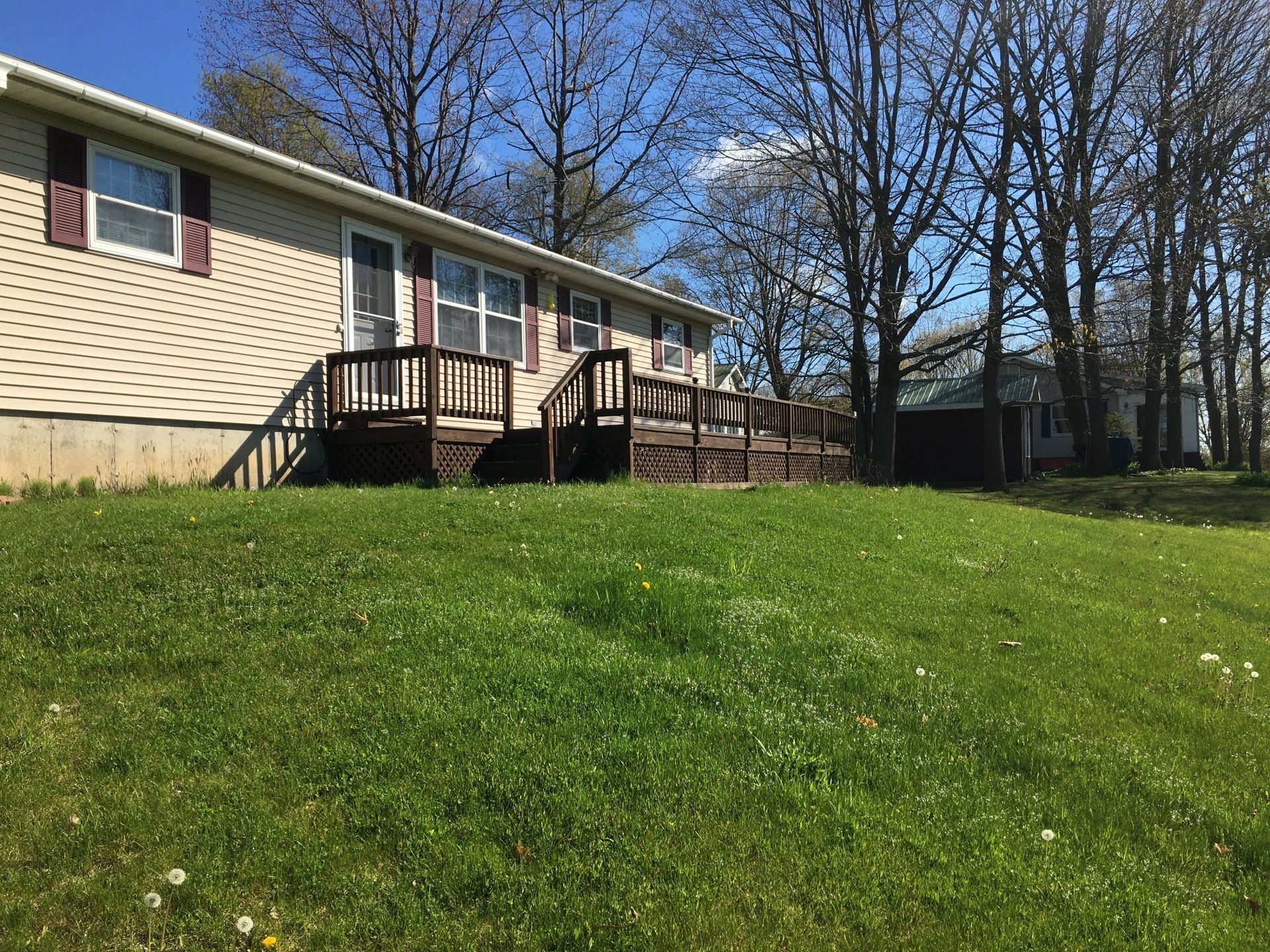 A mobile home with a large lawn in front of it.