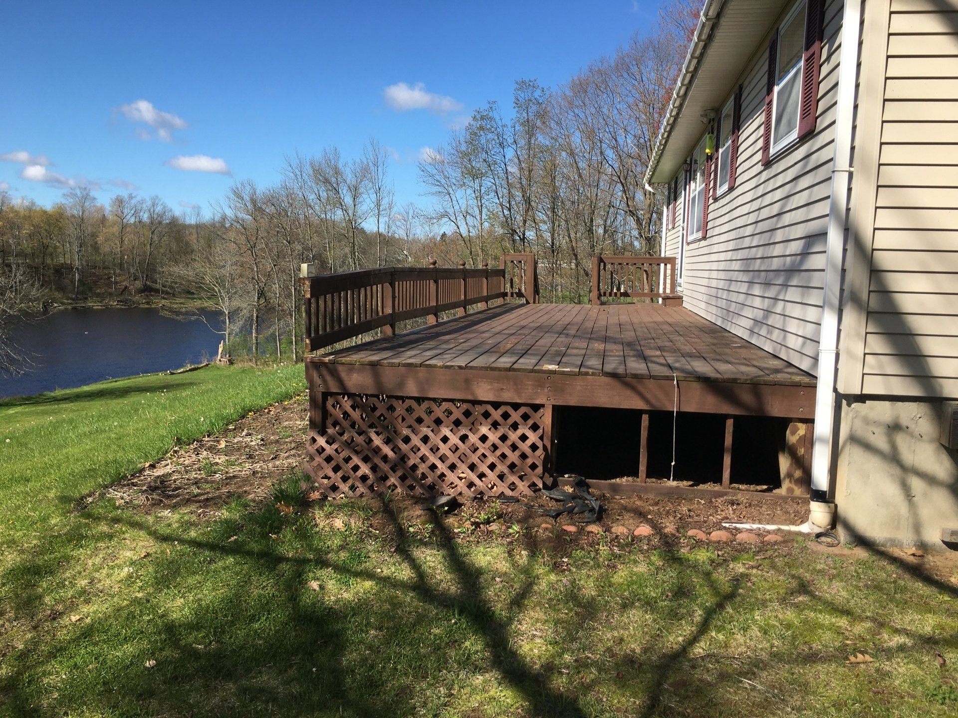 A house with a large wooden deck overlooking a river.