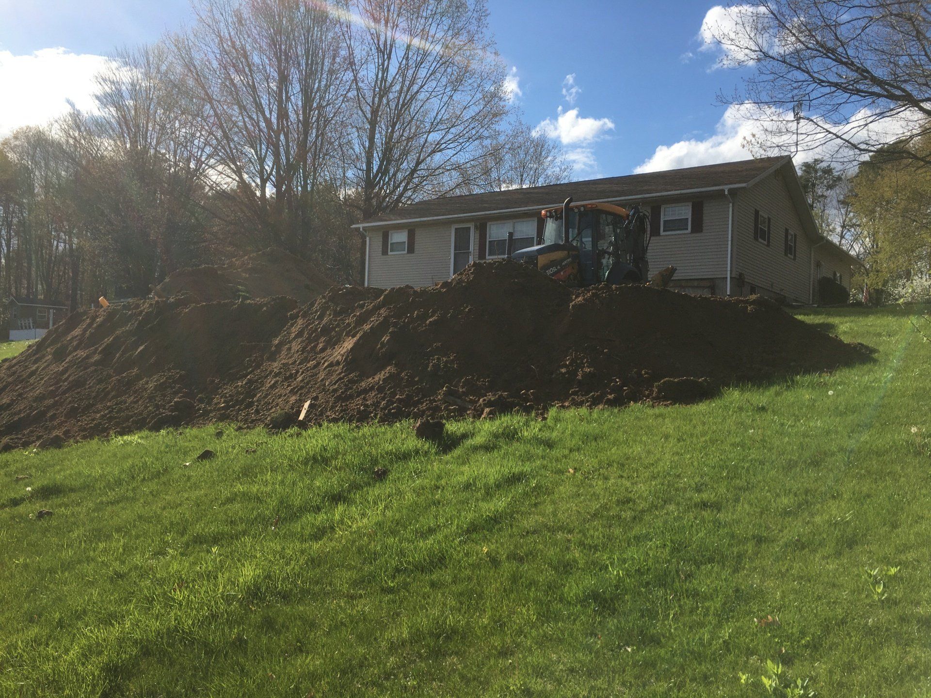 A house with a large pile of dirt in front of it.