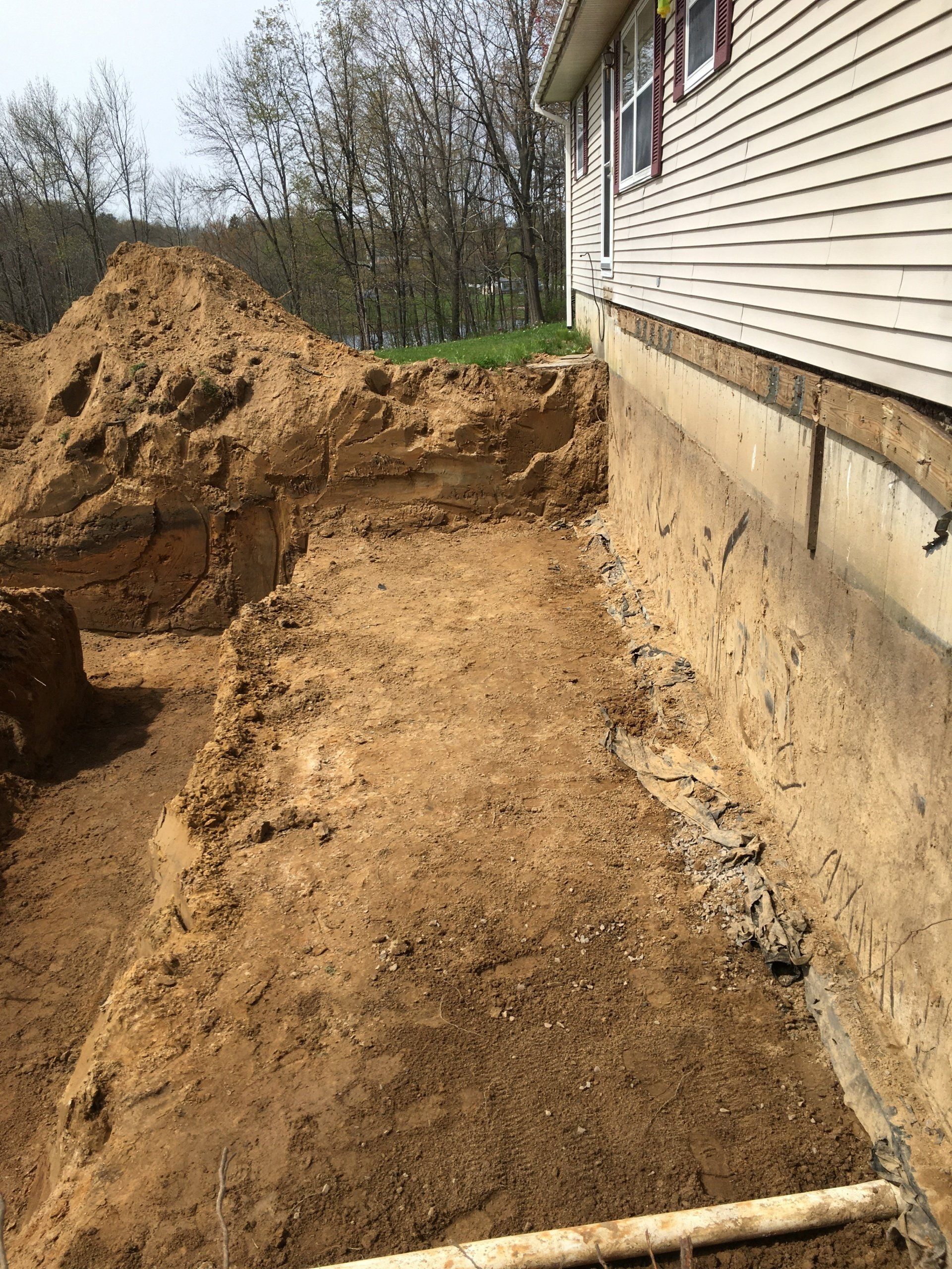 A large pile of dirt is sitting in front of a house.