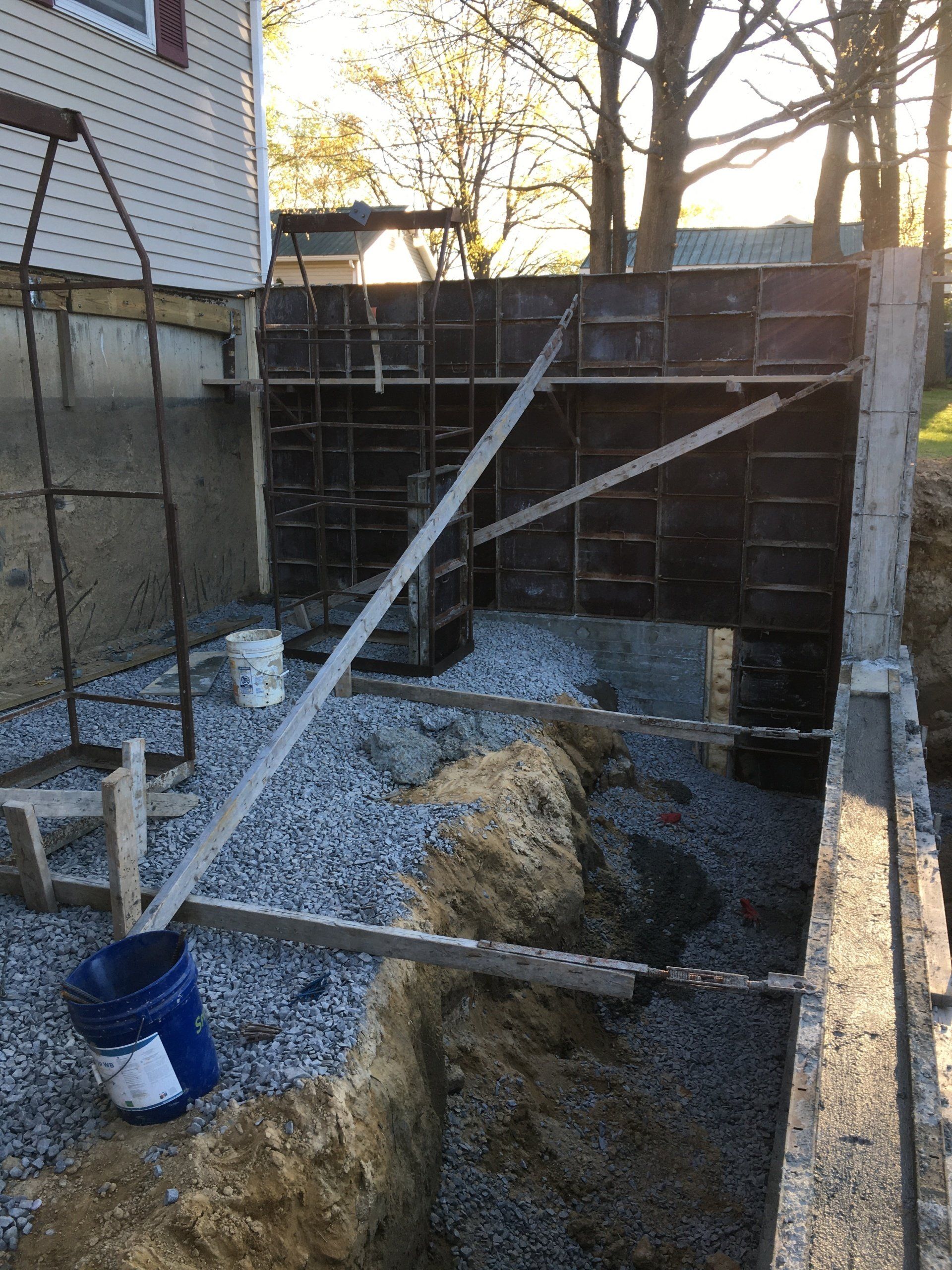 A concrete wall is being built in front of a house.