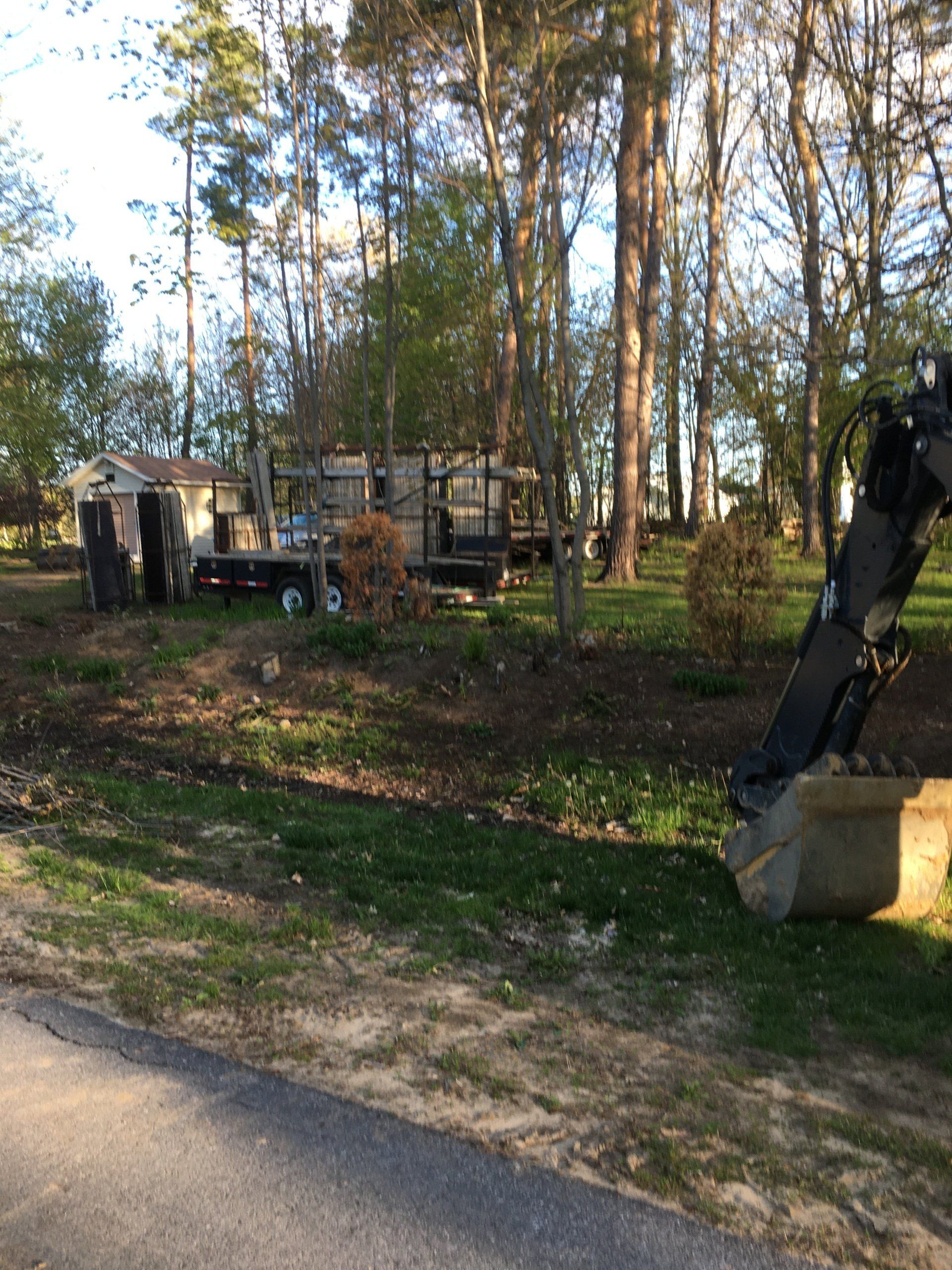 A large excavator is digging a hole in a yard.