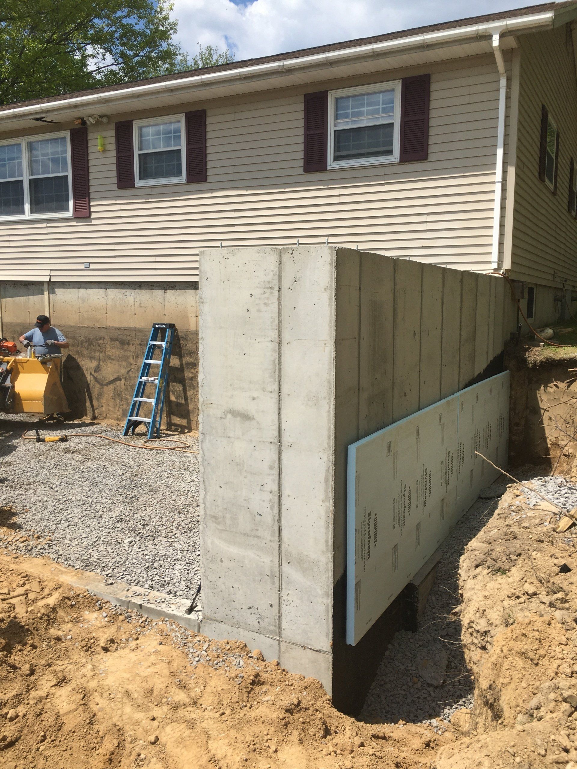 A concrete wall is being built in front of a house.