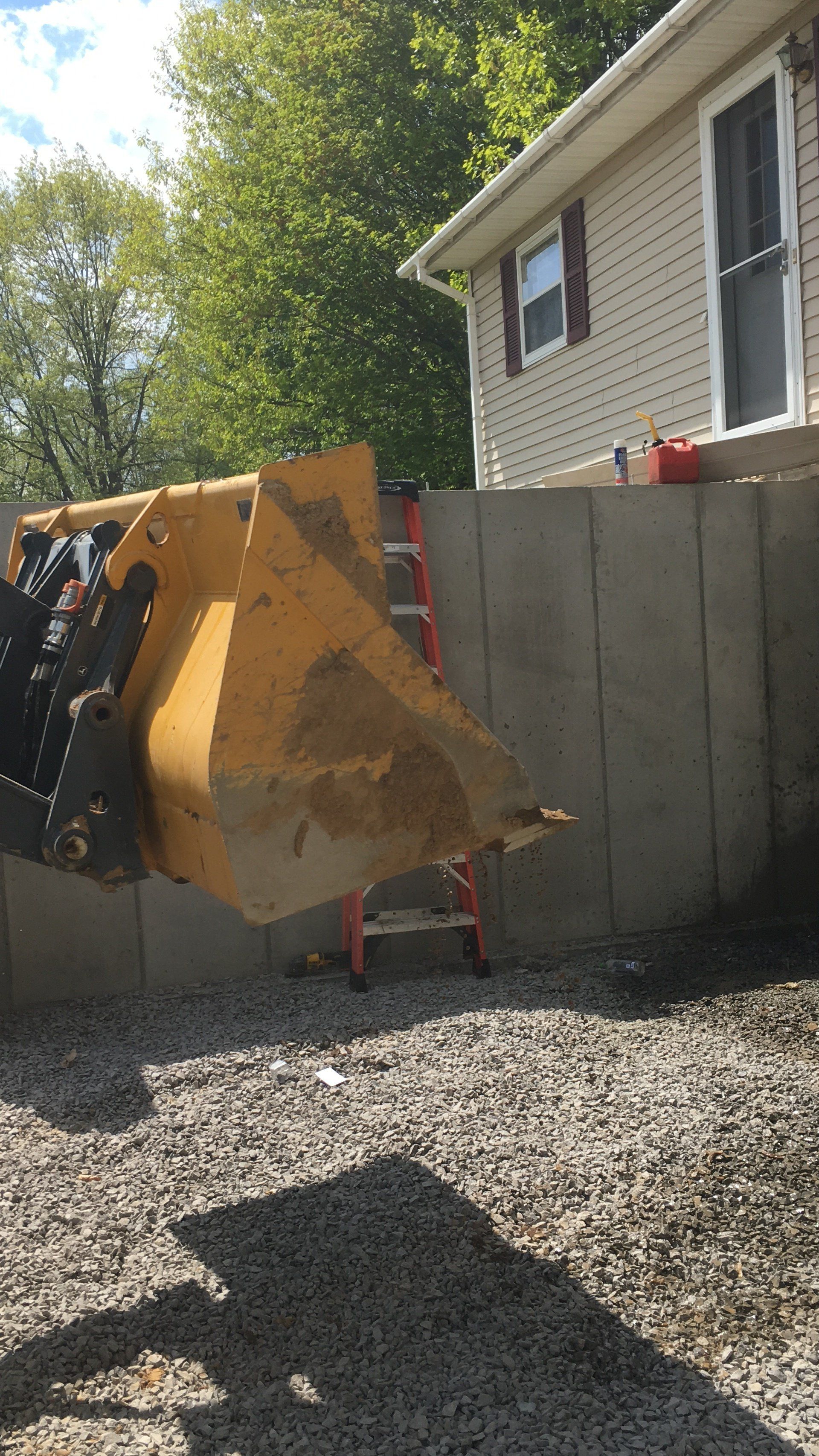A yellow bulldozer is parked in front of a house.