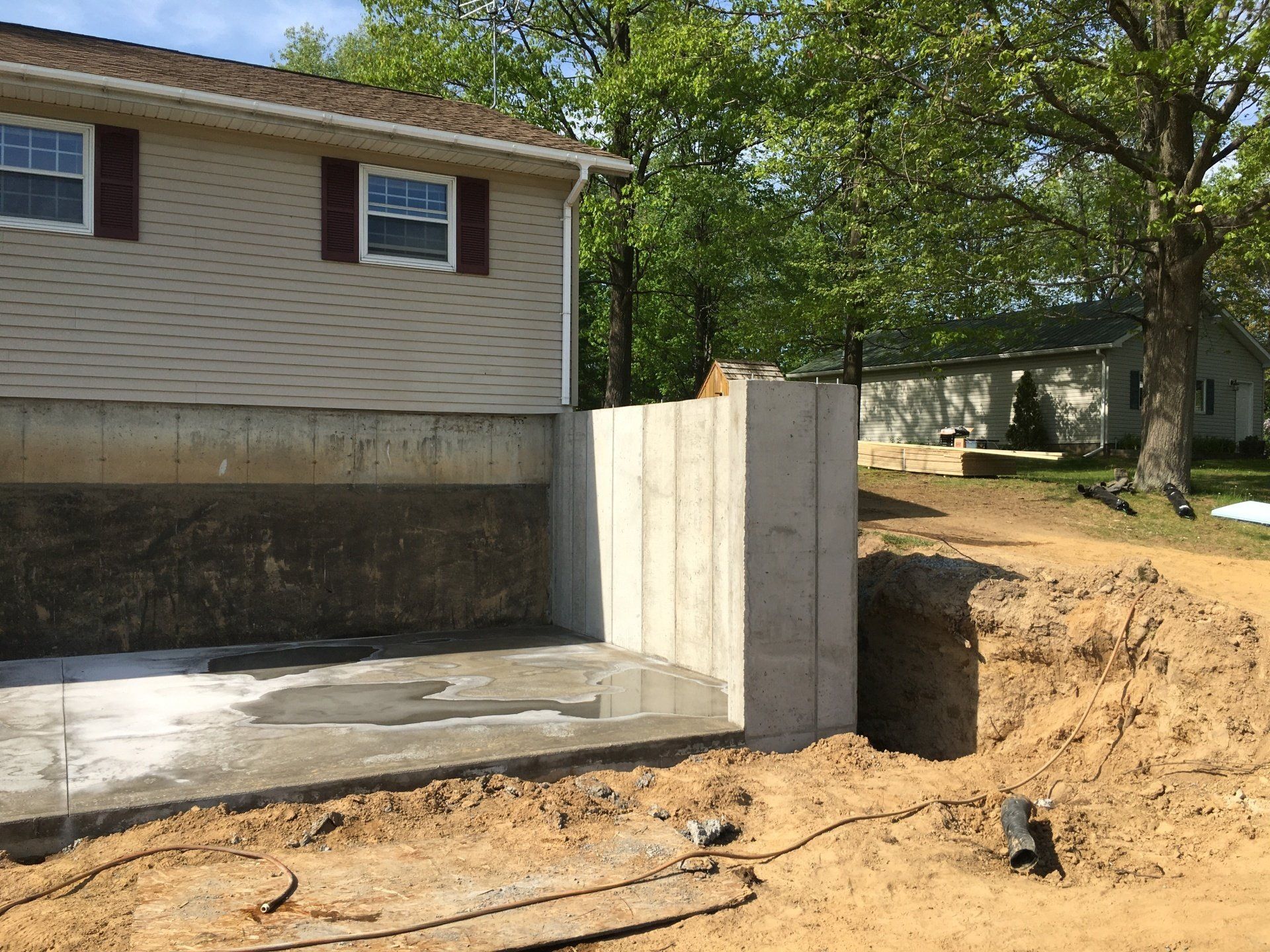 A concrete wall is being built in front of a house.