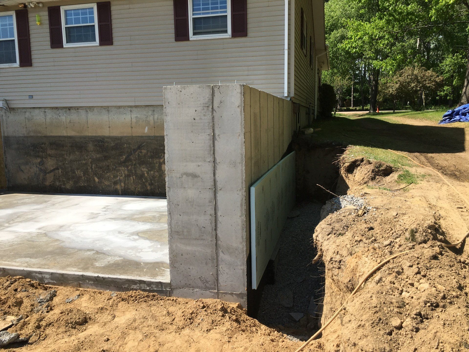 A concrete wall is being built in front of a house.