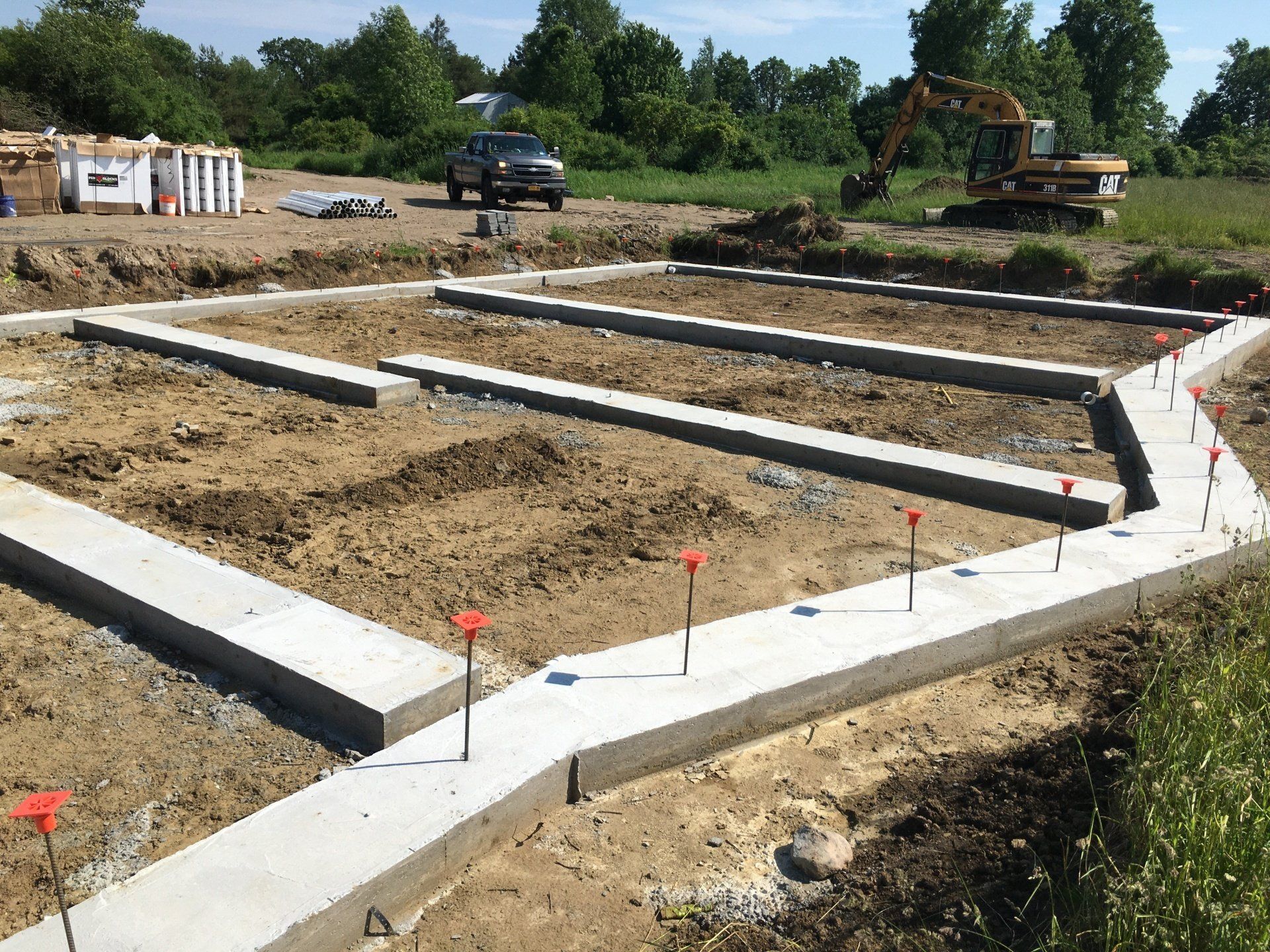 A construction site with a concrete walkway and a bulldozer in the background.