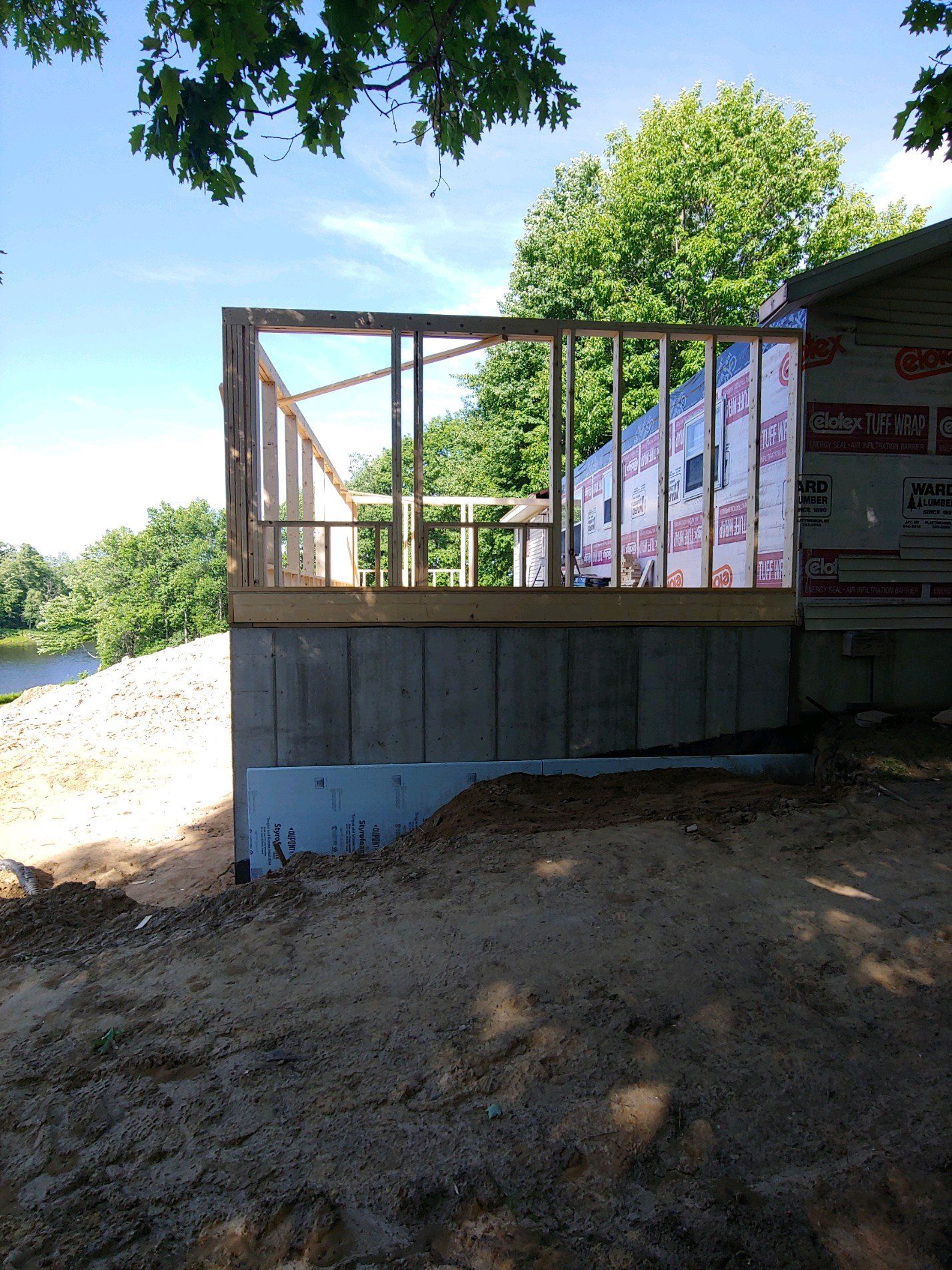 A house is being built on a hill next to a river.