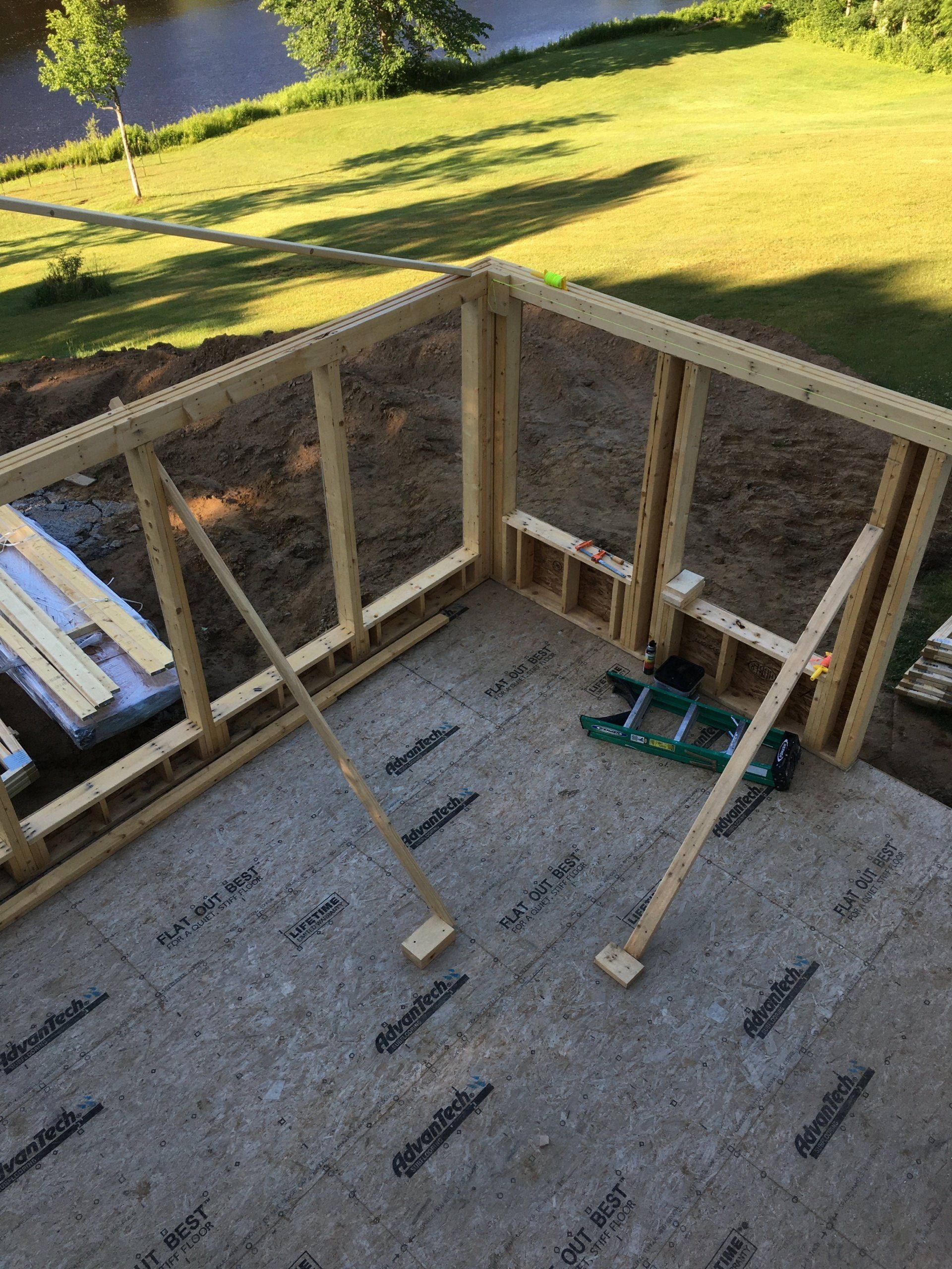 A wooden structure is being built next to a river.