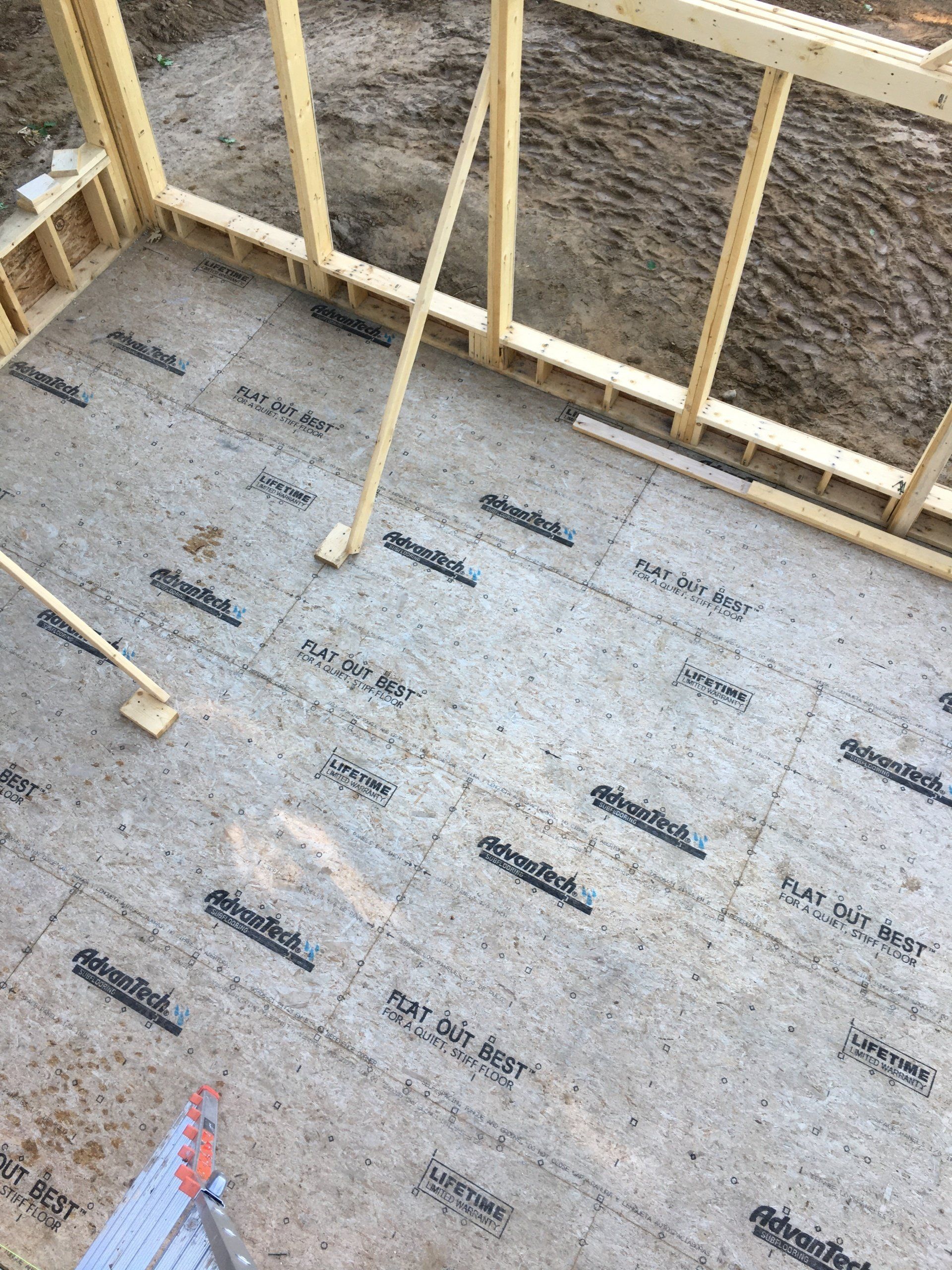A room under construction with a wooden frame and a concrete floor.