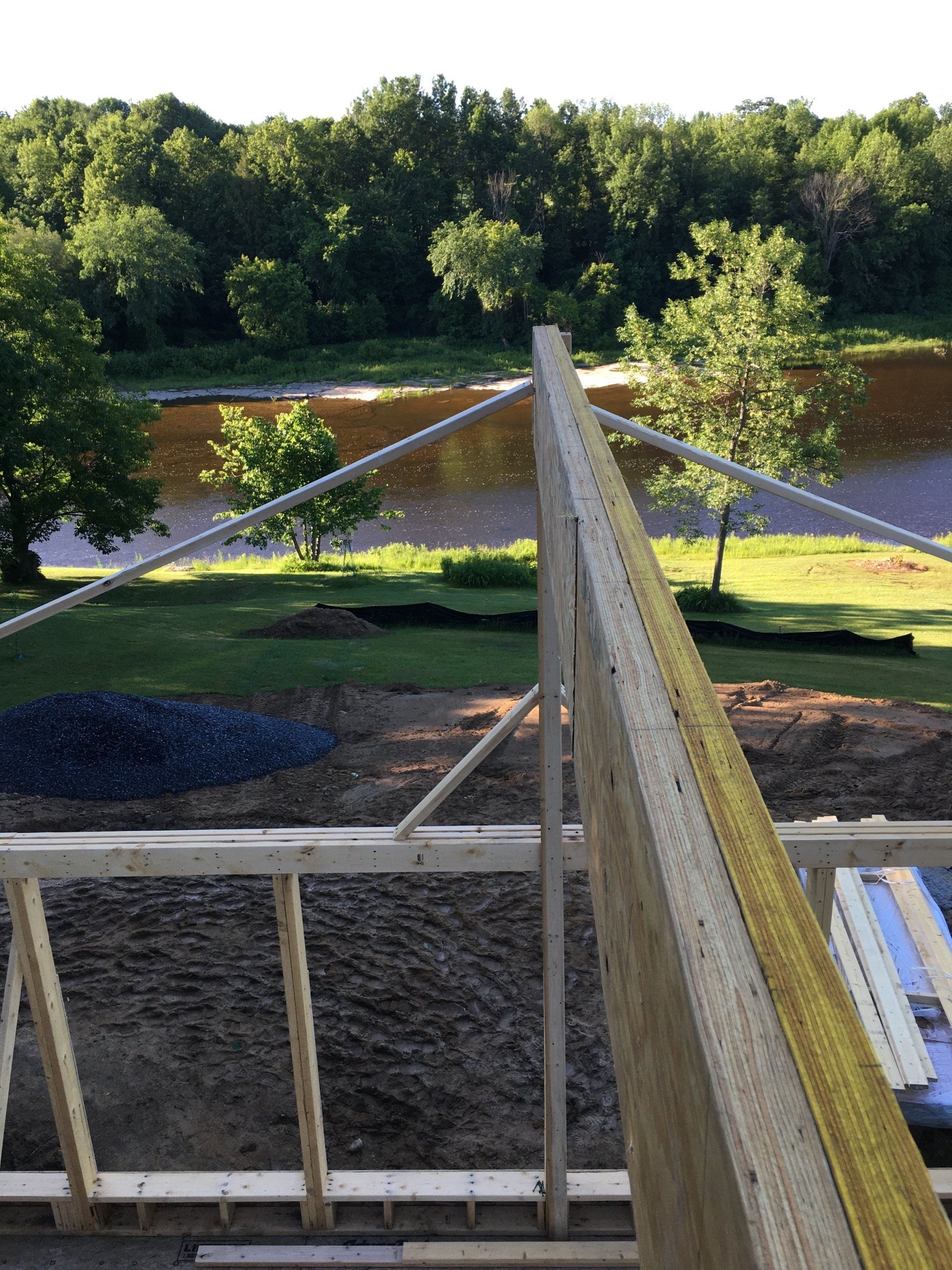 A wooden structure is being built with a river in the background