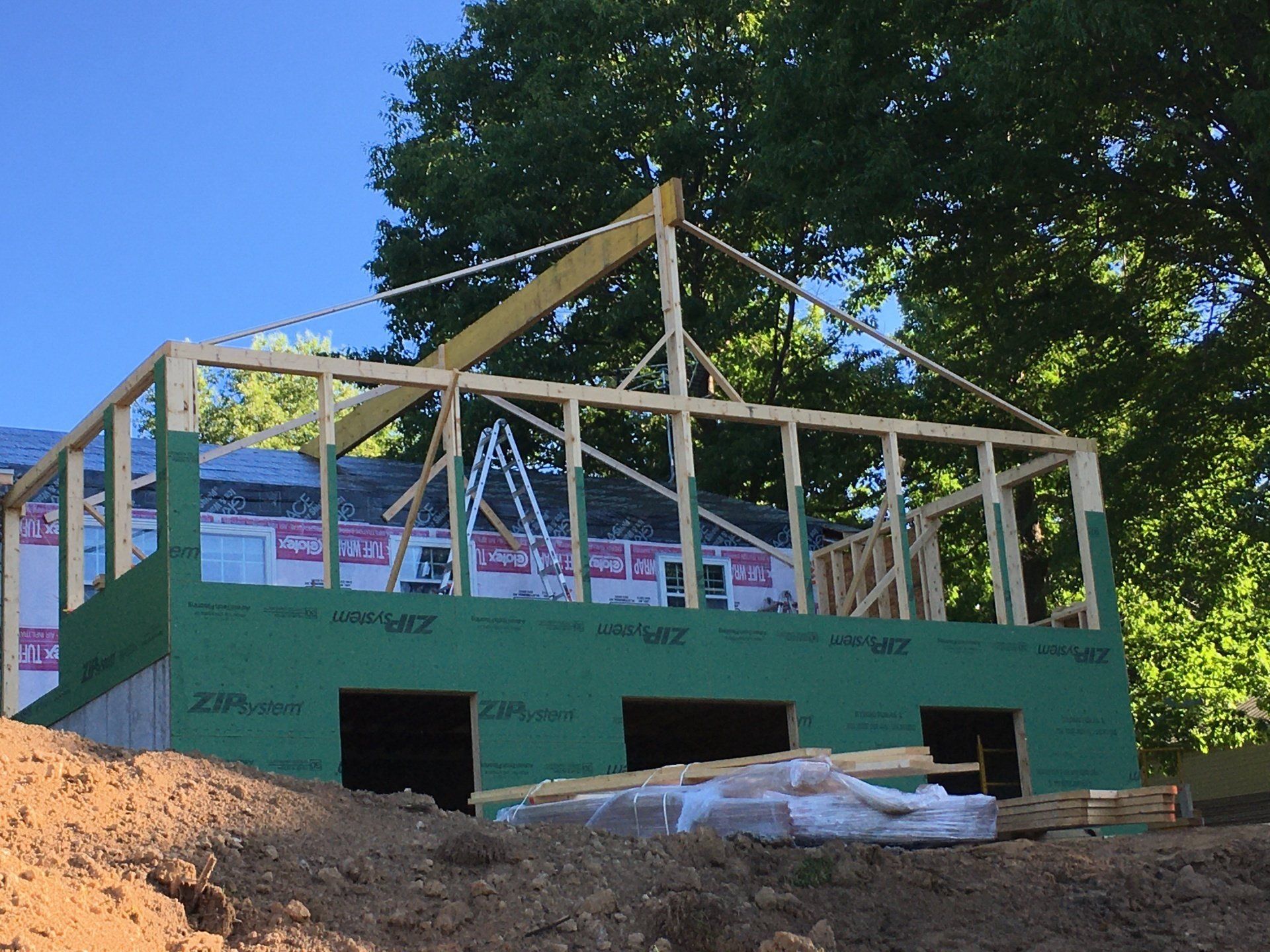 A house is being built on top of a dirt hill.