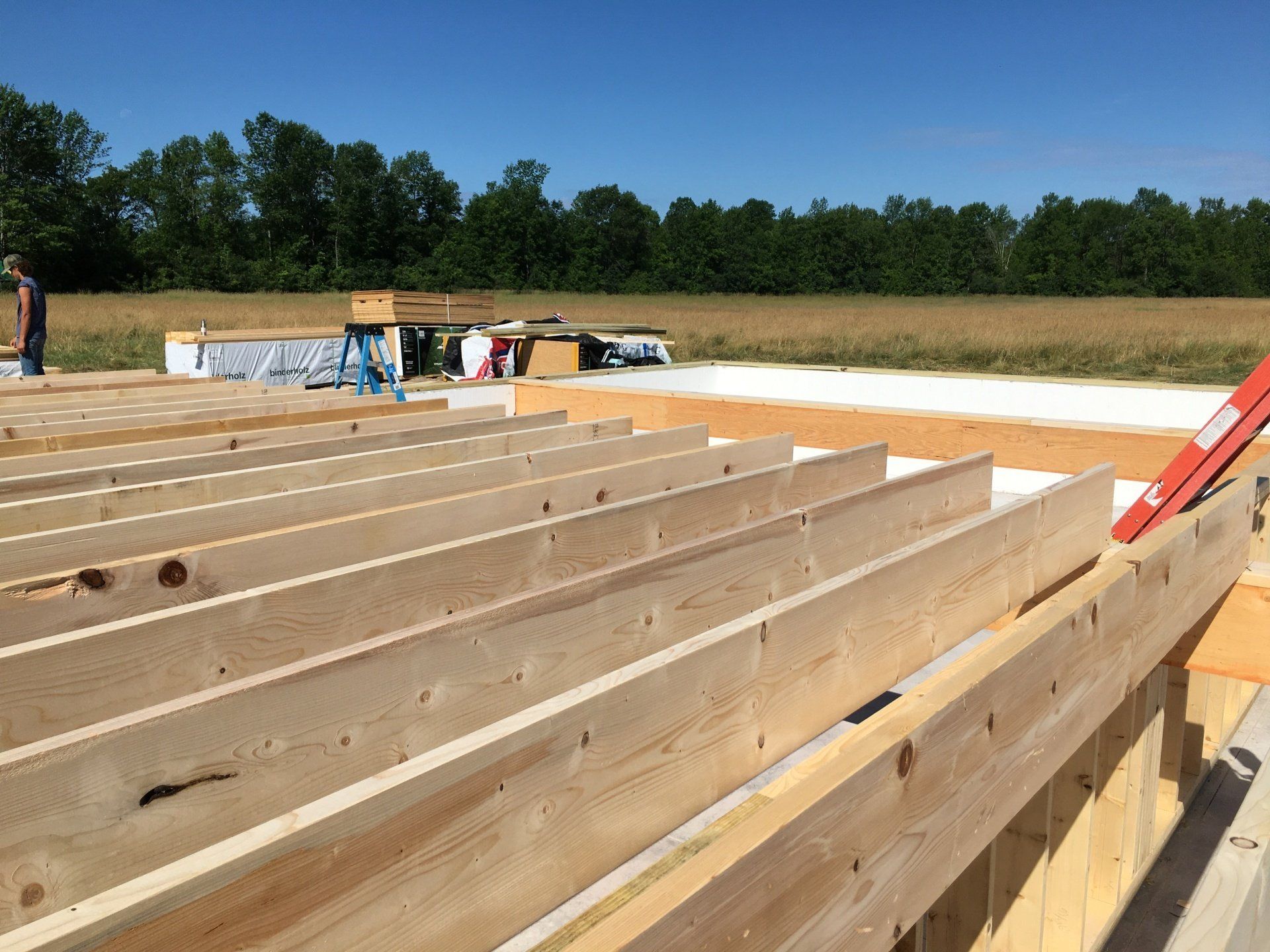 A row of wooden beams are sitting on top of each other on a construction site.